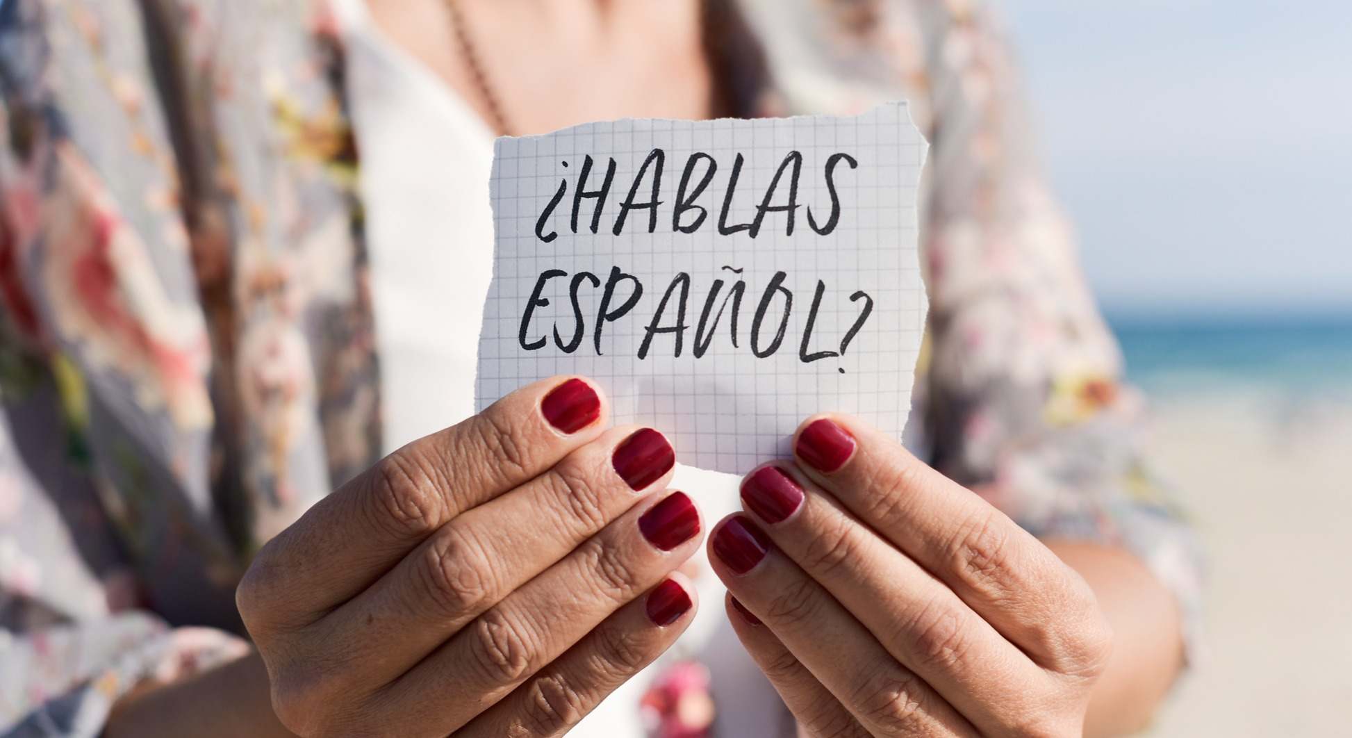 Mujer sosteniendo un cartel que reza '¿Hablas español?'