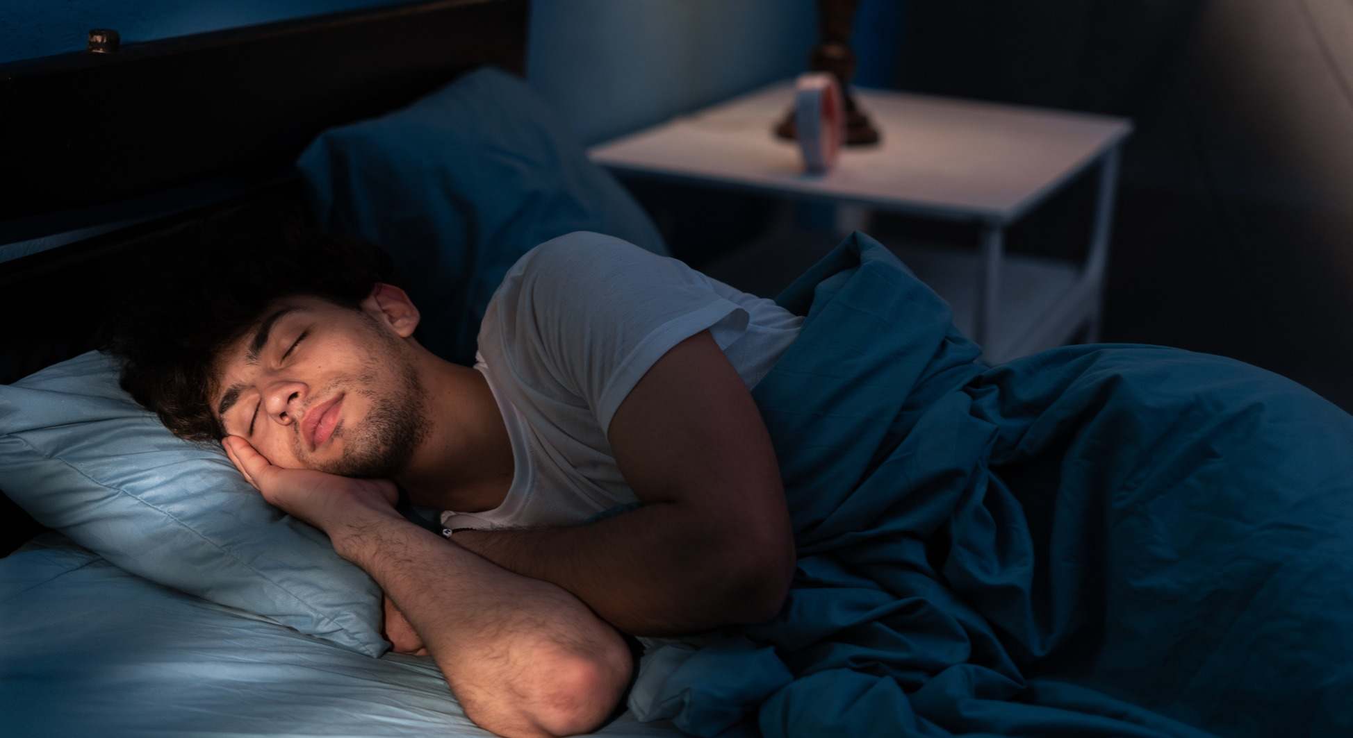 Hombre durmiendo en su cama por la noche