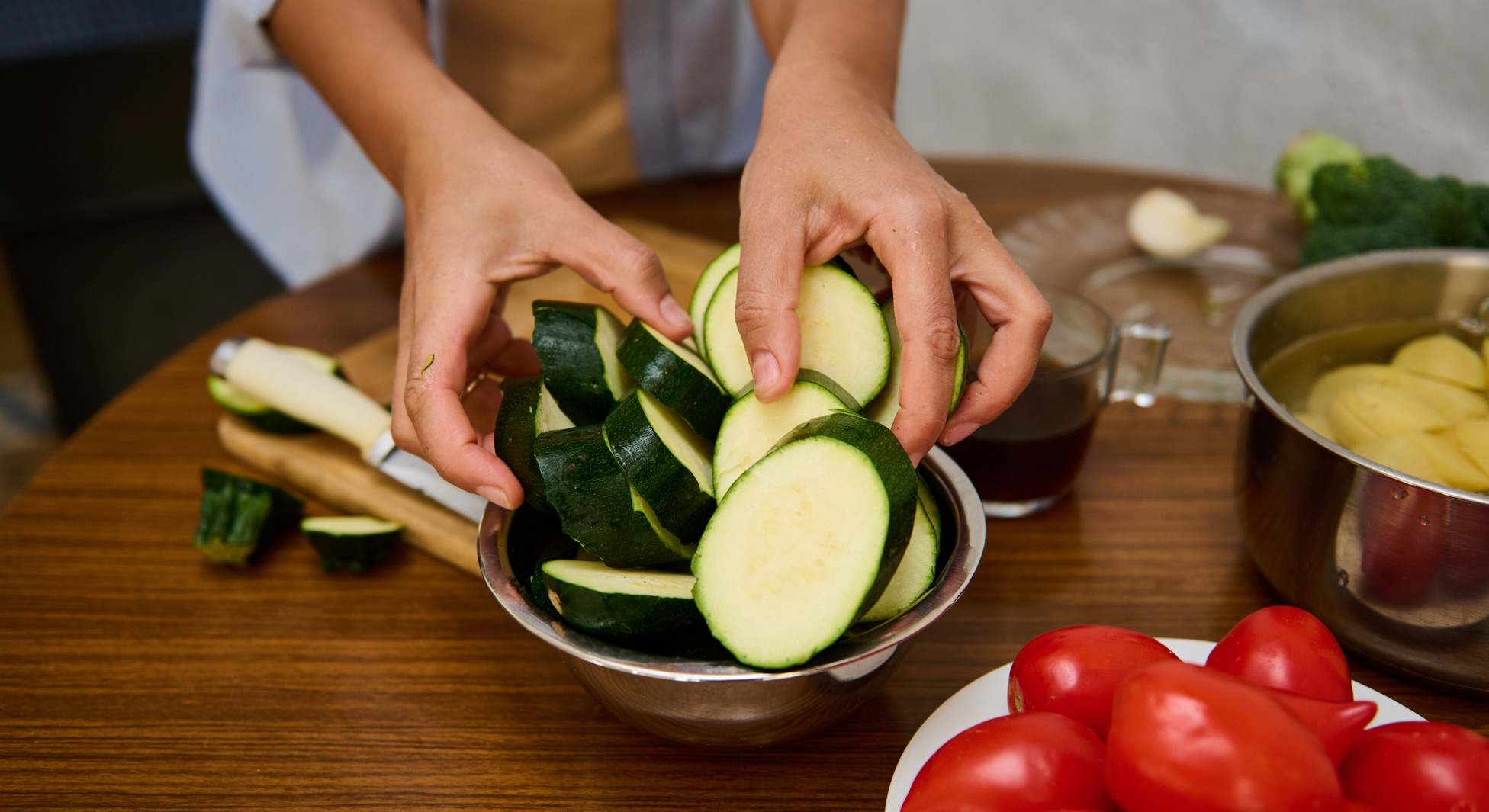 Manos preparando calabacín