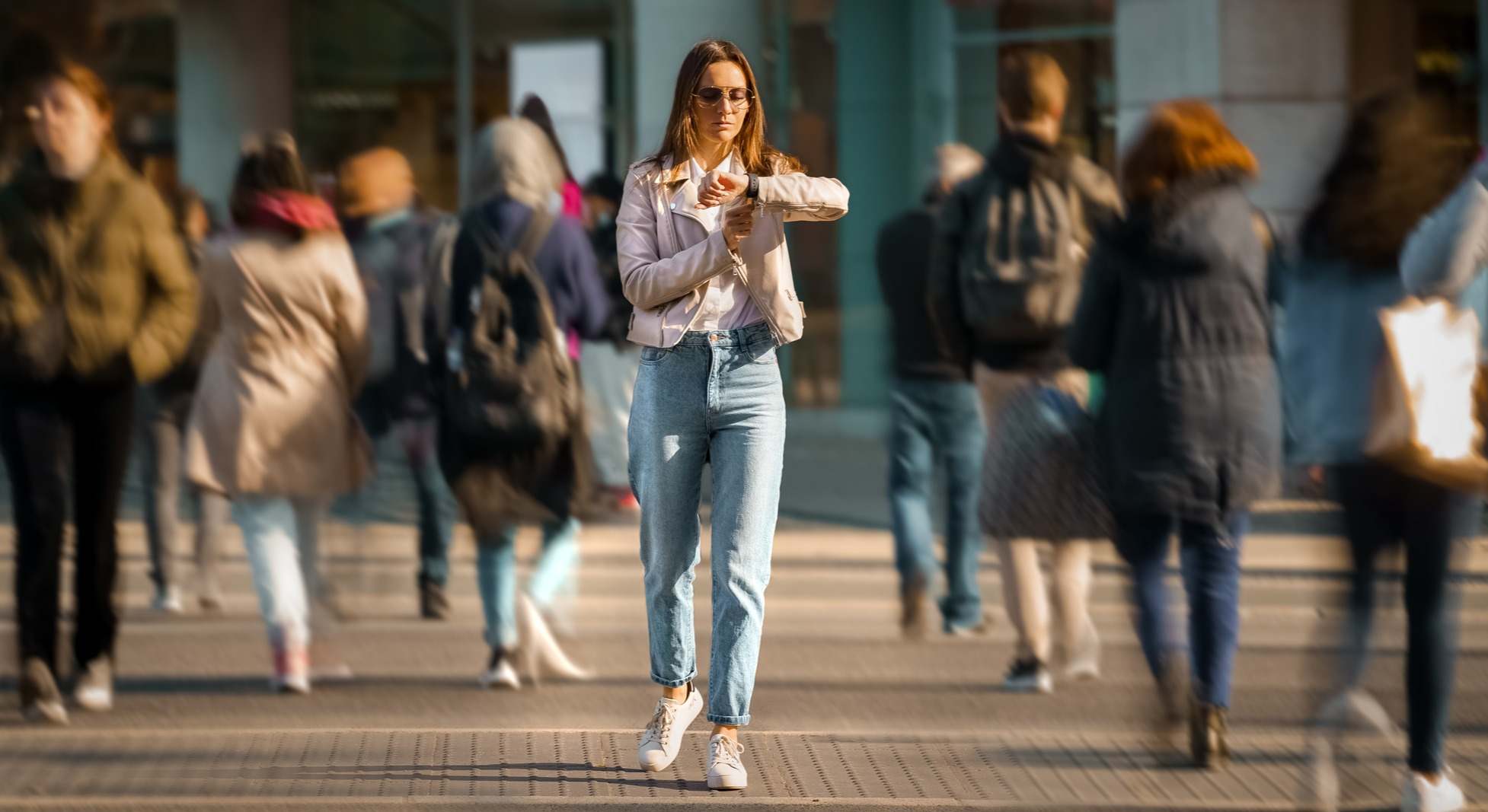Mujer mirando su reloj mientras camina por la calle