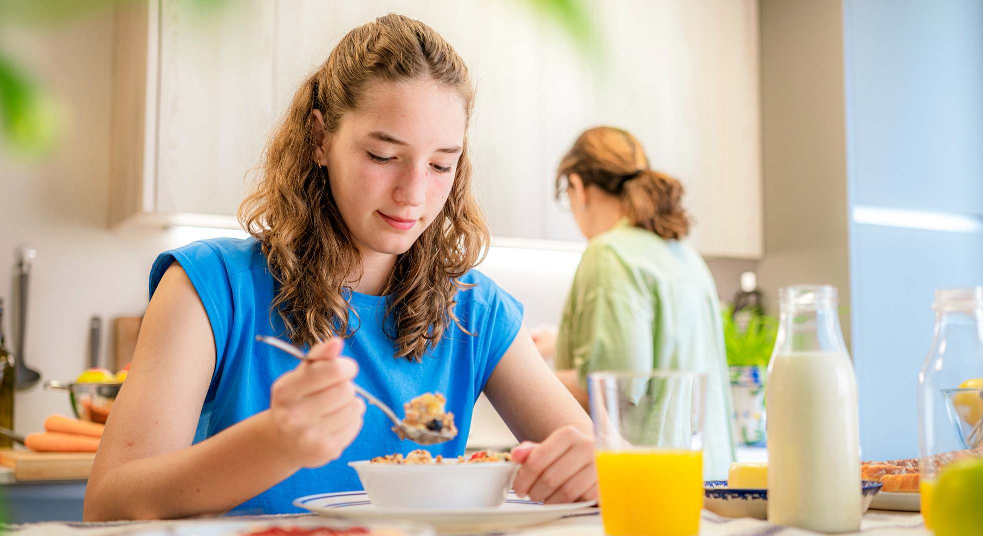 Joven desayunando en la cocina de su casa