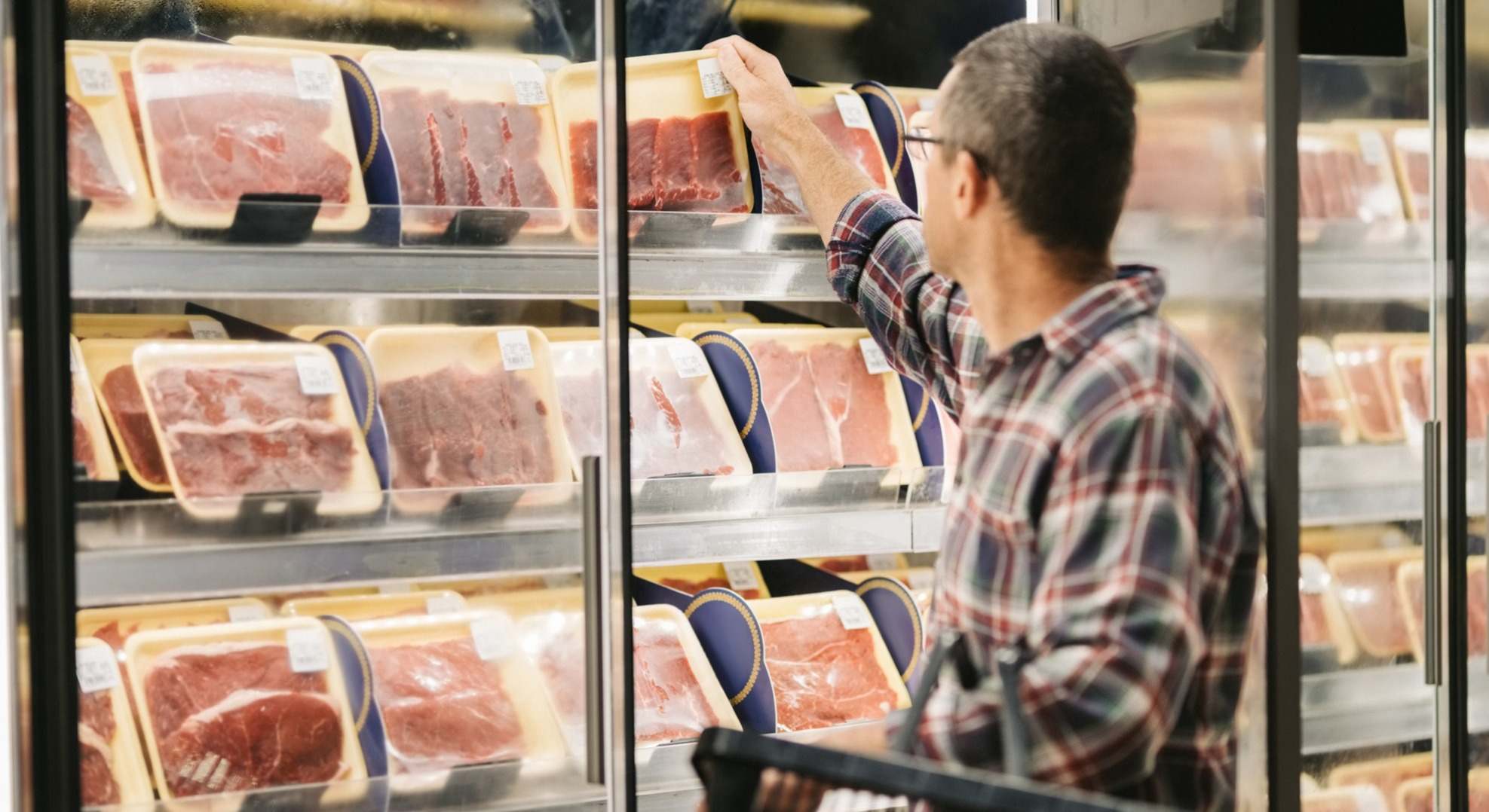 Un hombre comprando carne en el supermercado