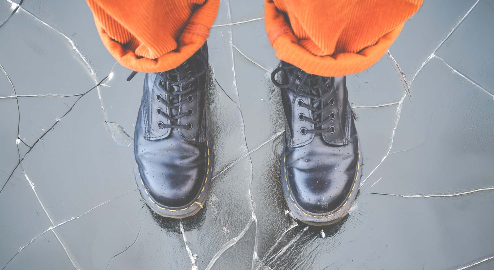 Unas piernas con botas sobre hielo fino resquebrajándose