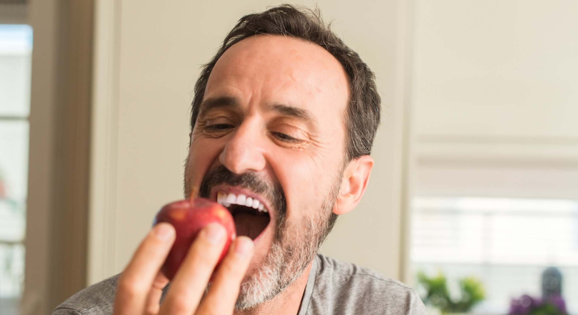 Hombre mordiendo una manzana