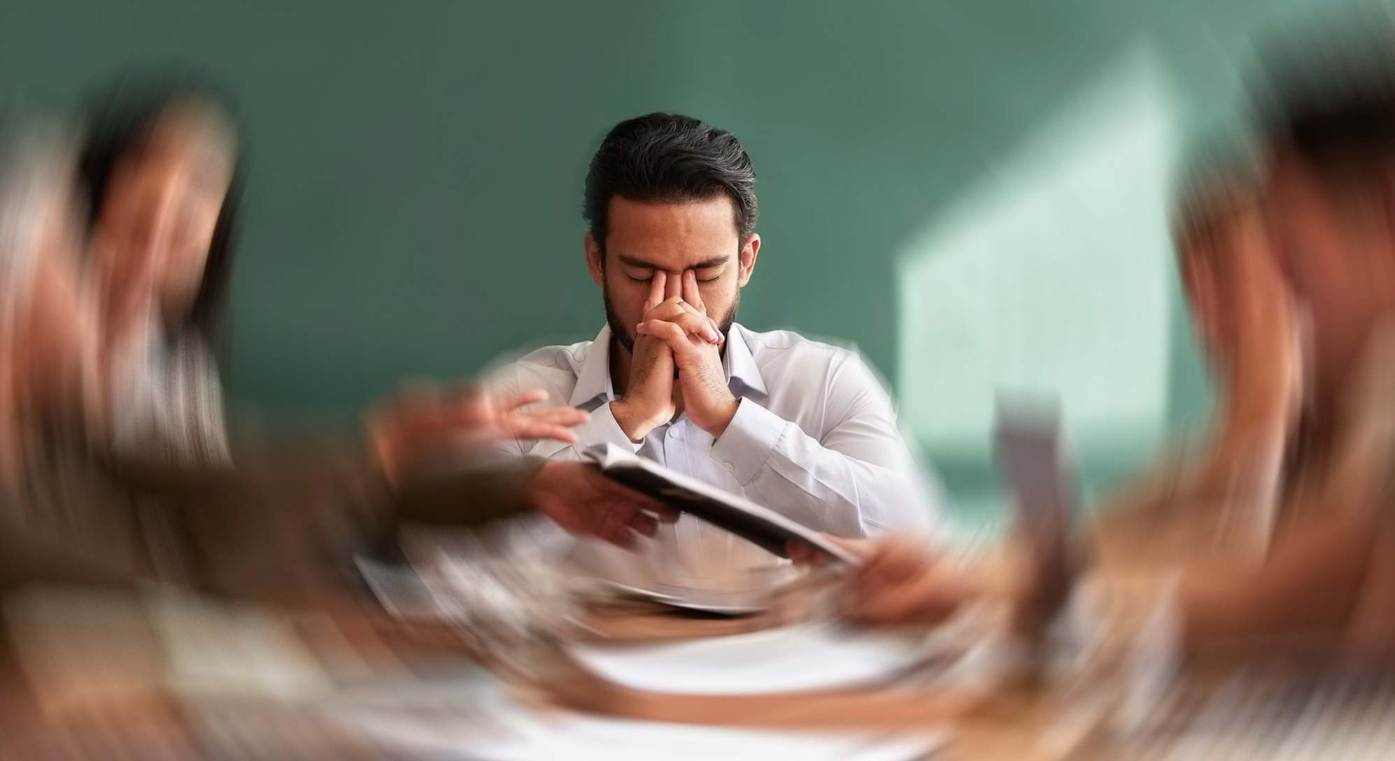 Hombre con estrés y las manos sobre la cara con personas a su alrededor distorsionadas