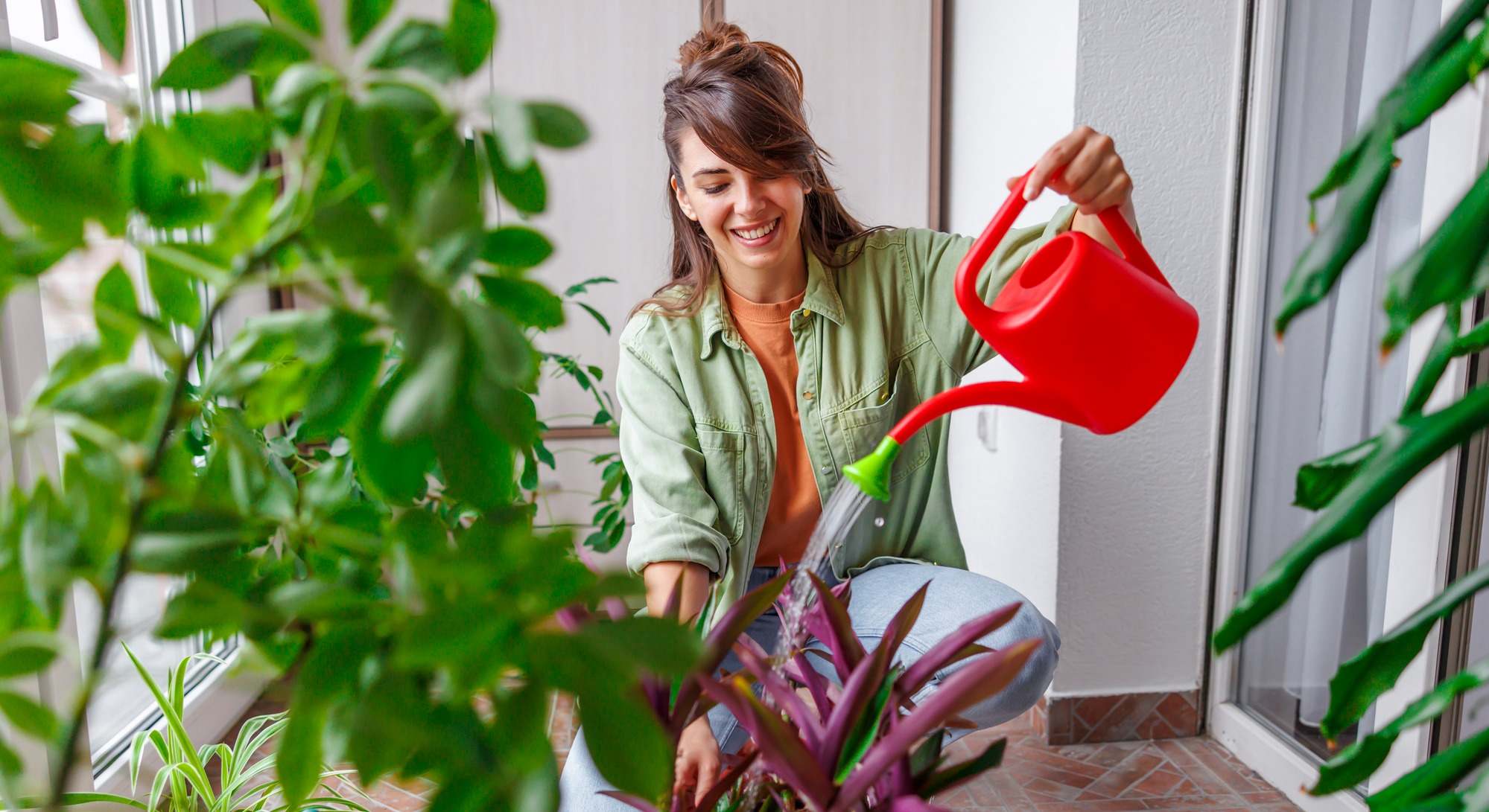 Mujer regando las plantas en su casa
