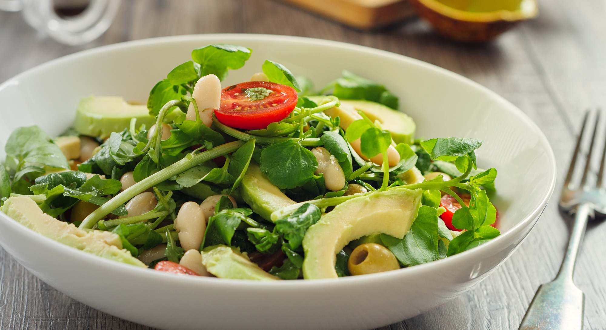 Alubias blancas sanas, ensalada de aguacate, tomates cherry y berros