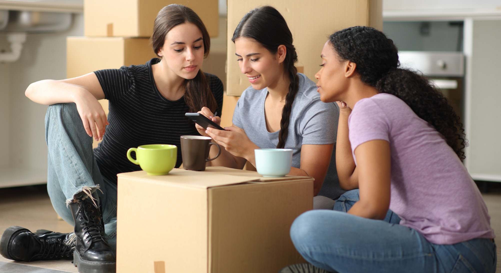 Jóvenes tomando café en una caja de mudanza