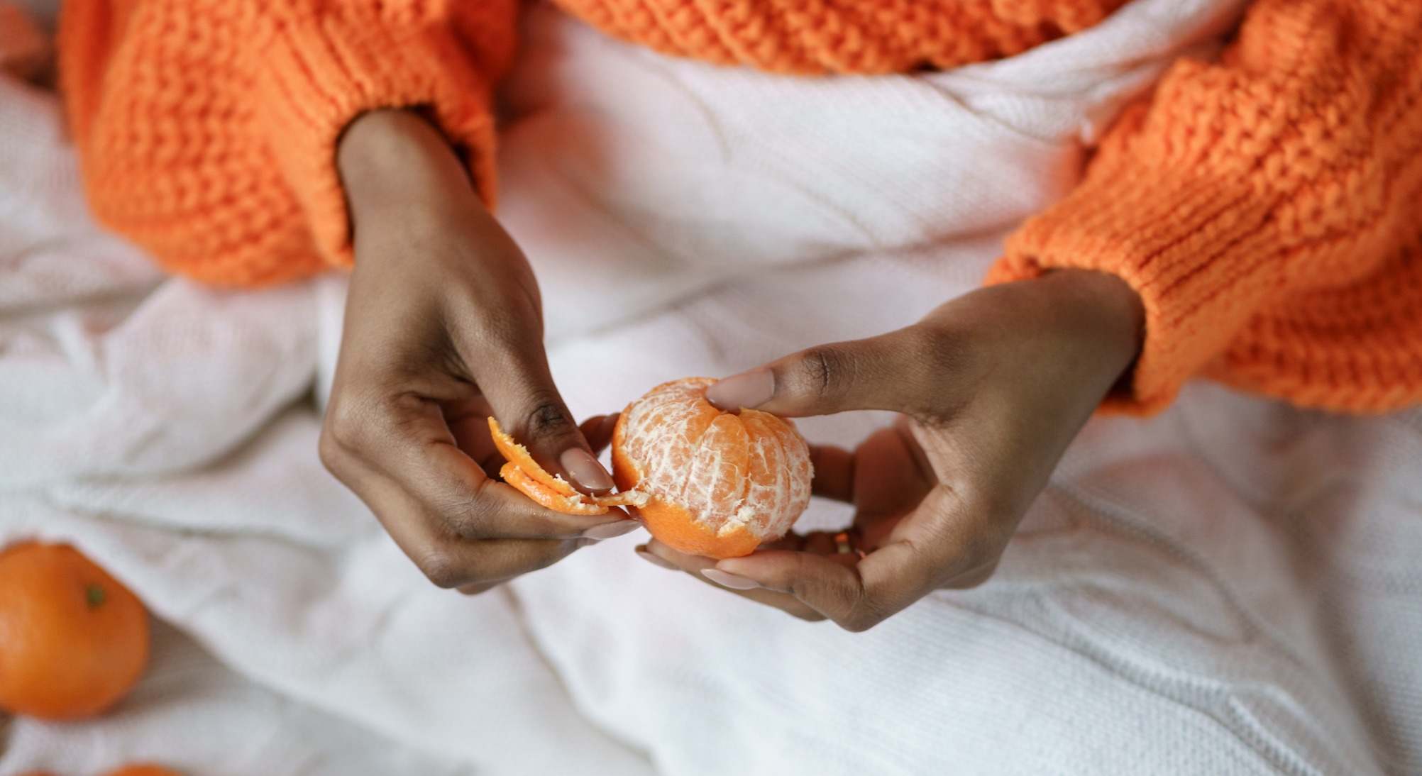Manos de mujer pelando una mandarina
