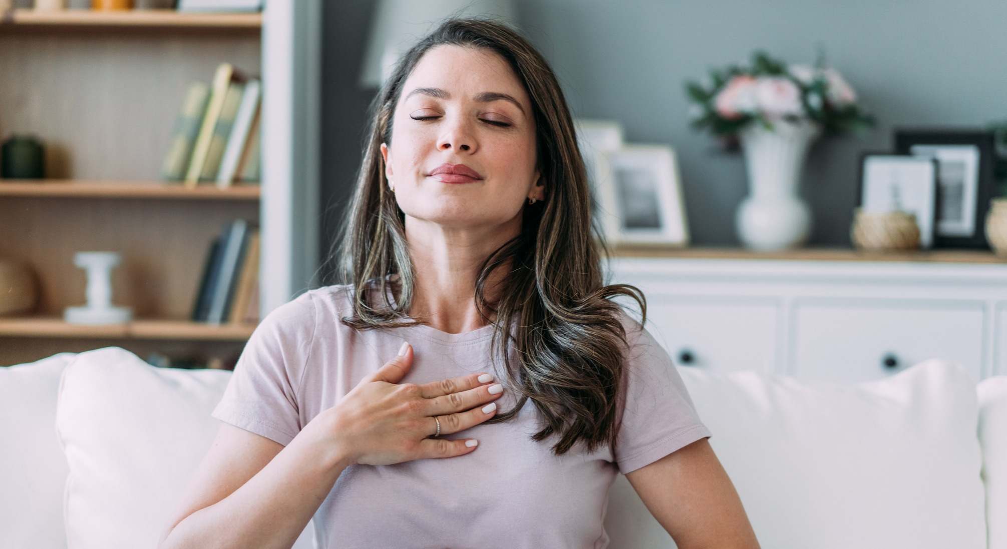 Mujer haciendo ejercicios de respiración con los ojos cerrados