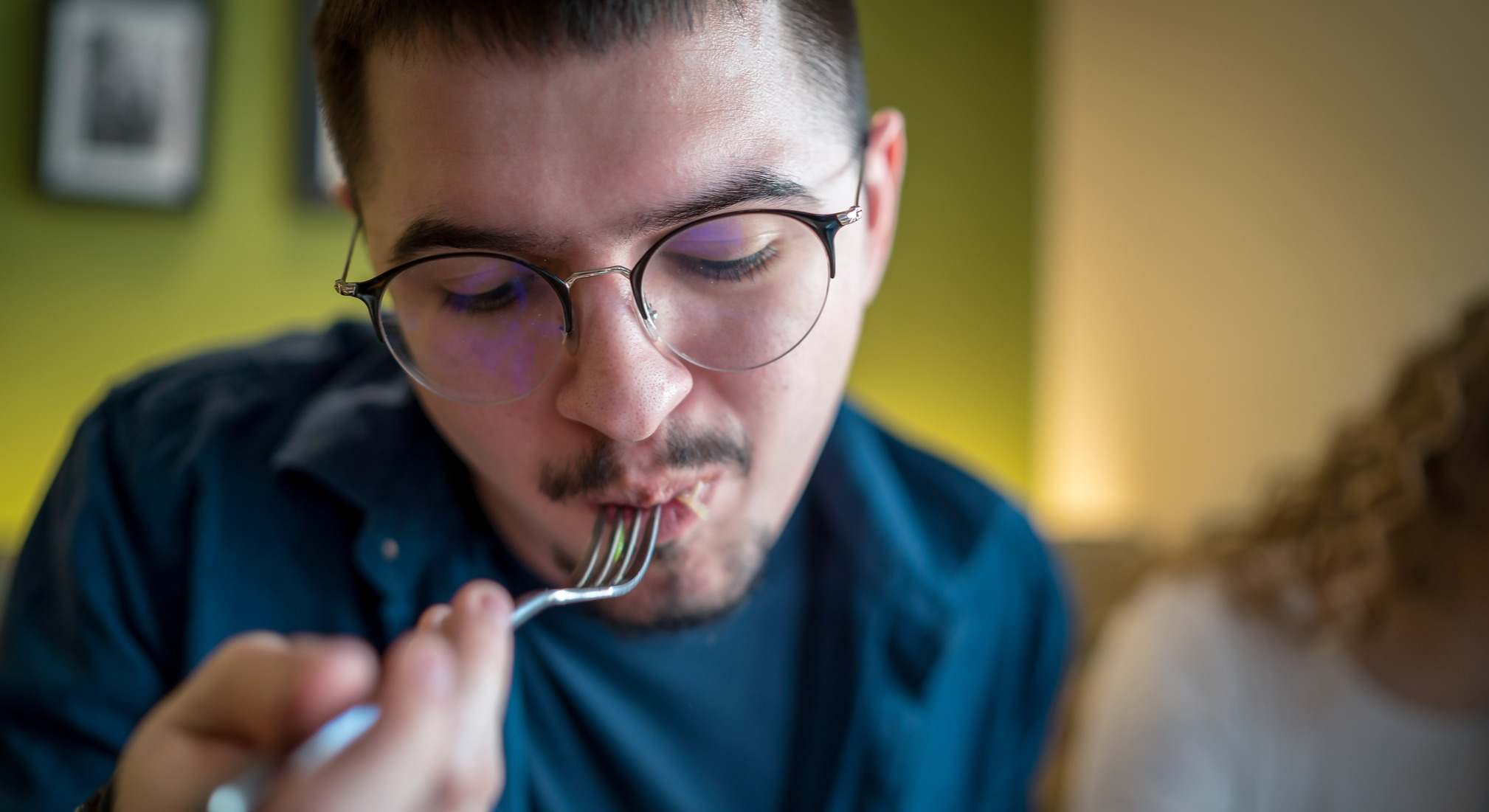 Persona introduciéndose un tenedor a la boca