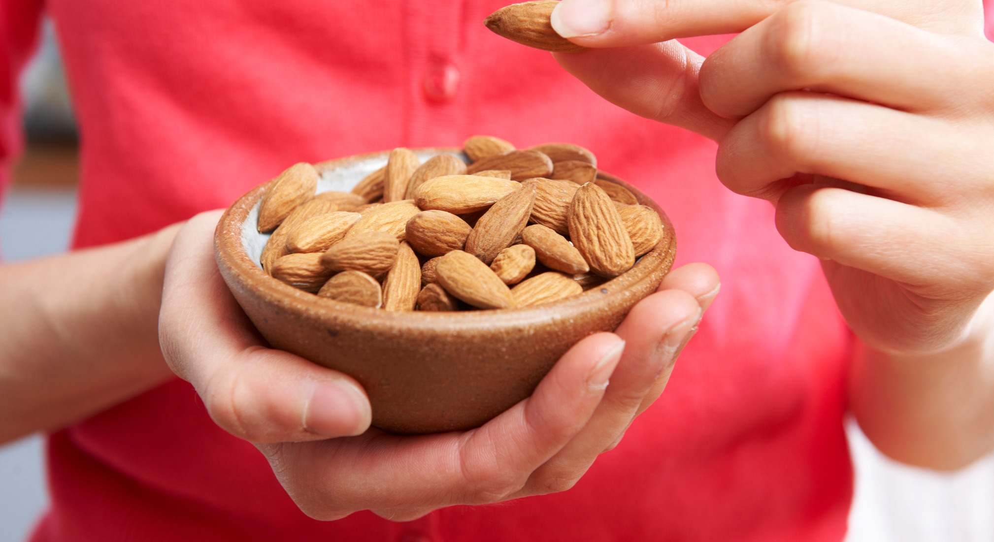 Mujer con un cuenco de almendras en las manos