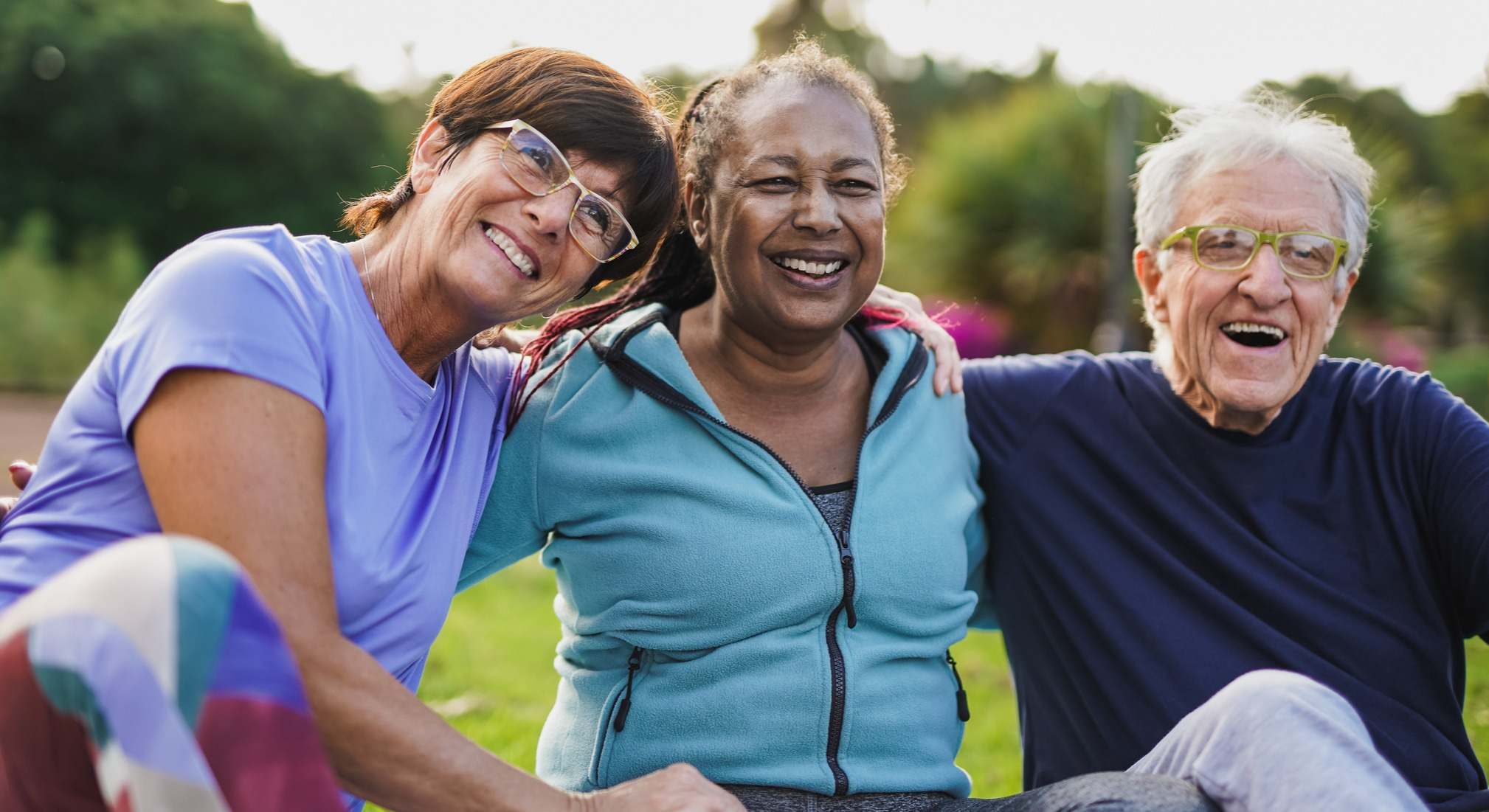 Personas de la tercera edad sentadas en el césped