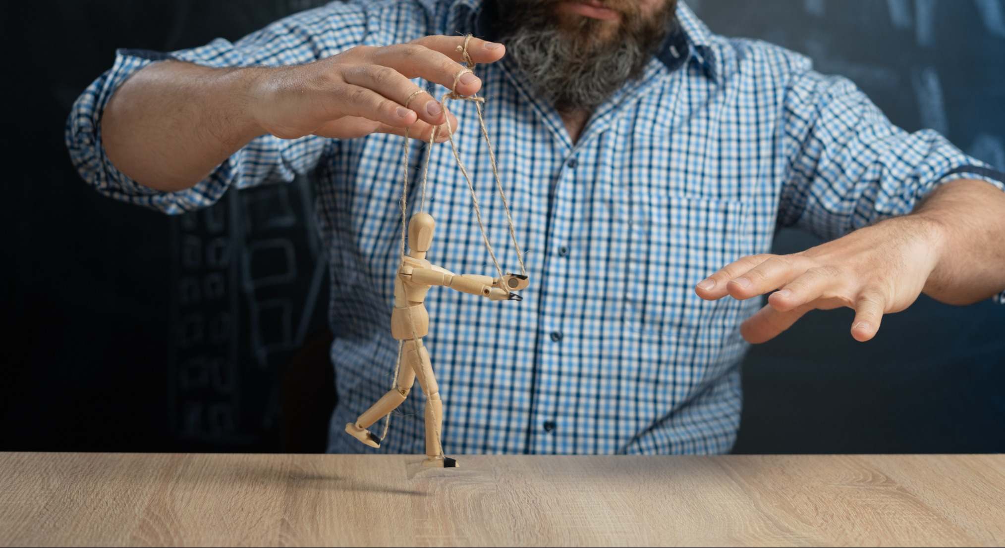Una marioneta en cuerdas en la mano del manipulador