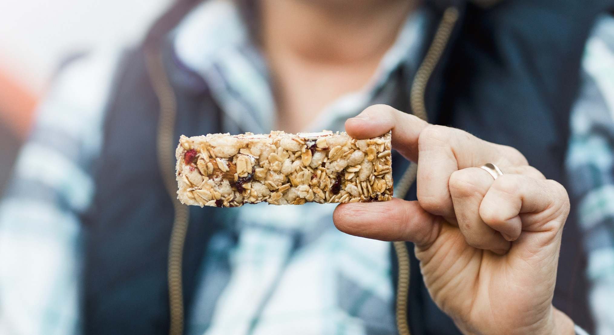 Mujer sujetando una barrita energética de cereales