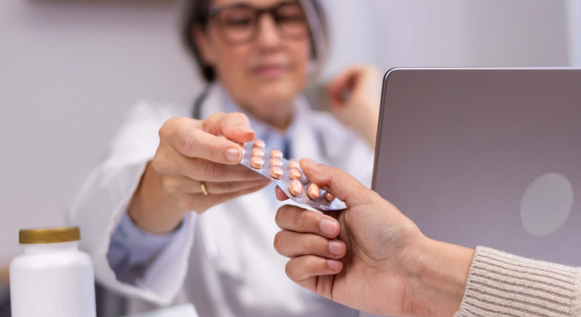 Médica dando pastillas a paciente
