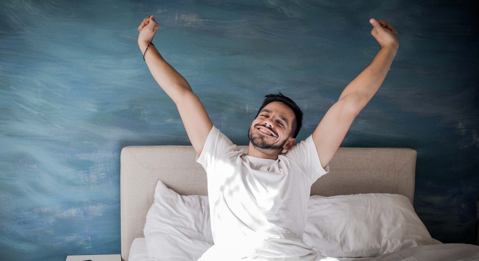 Hombre despertándose por la mañana en la cama