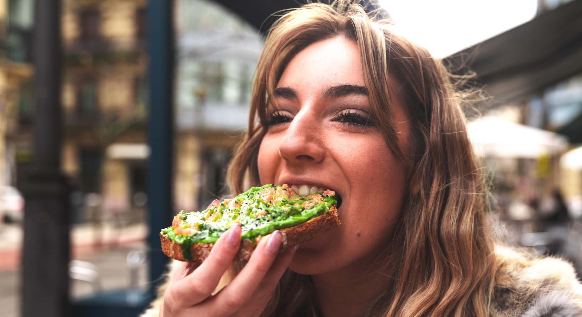 Chica comiendo una tostada de aguacate