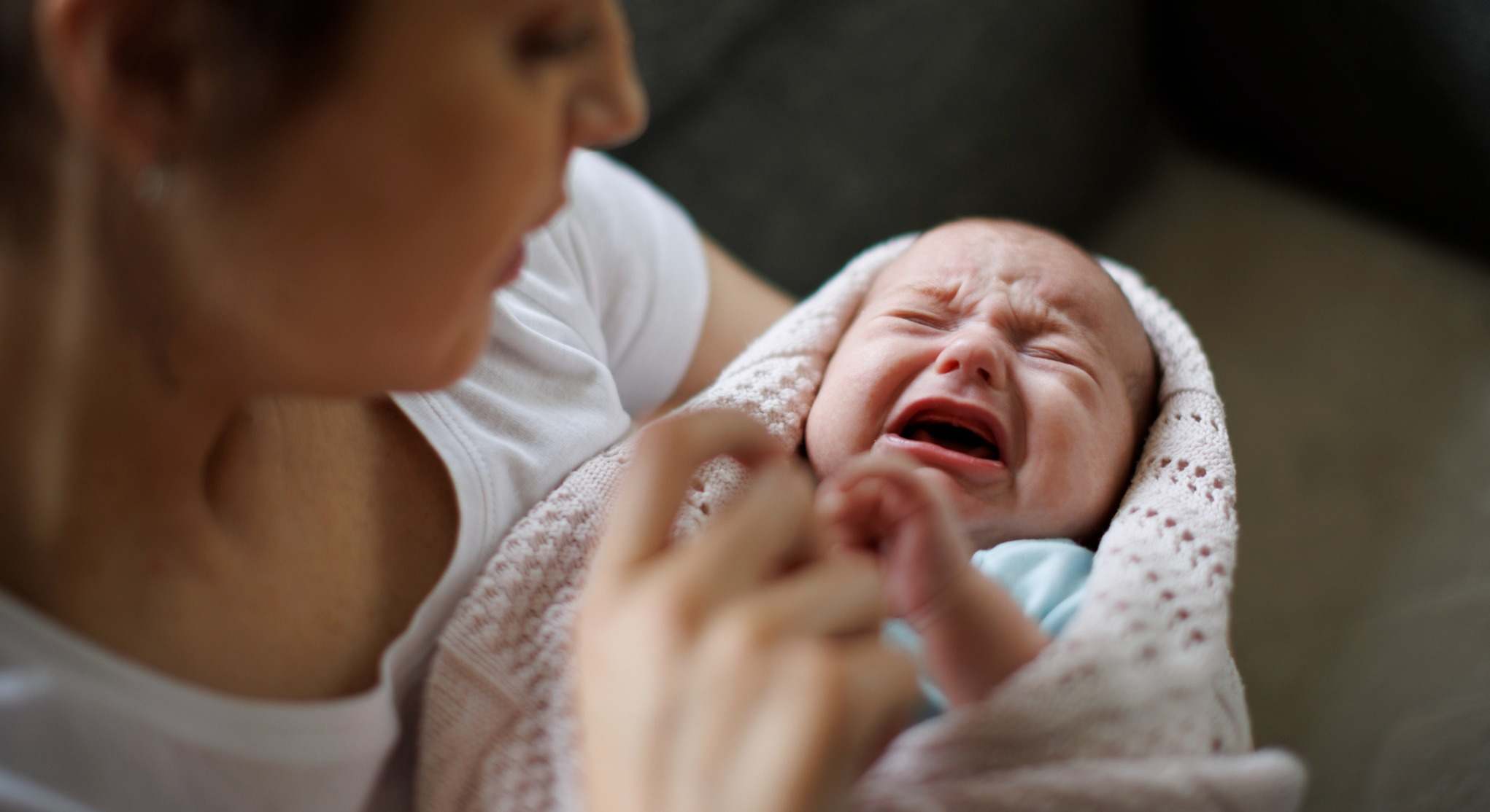 Bebé llorando en brazos de su madre