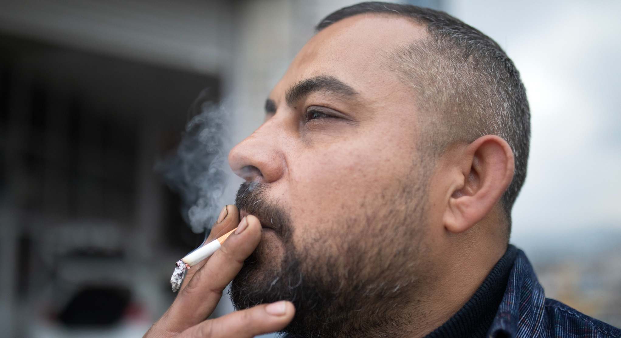Hombre fumando con un cigarrillo en la mano