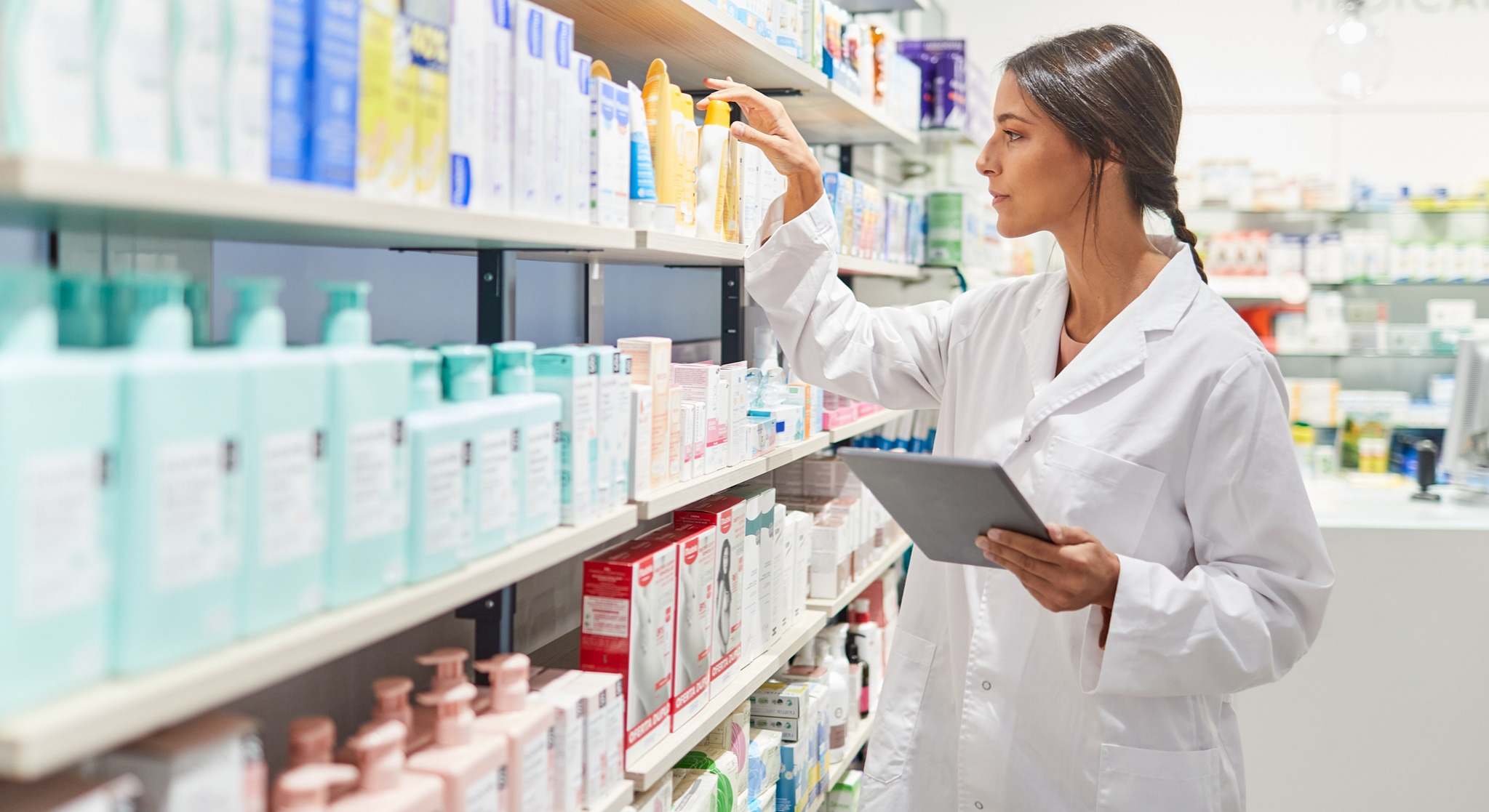 Farmacéutica colocando medicamentos en la estantería