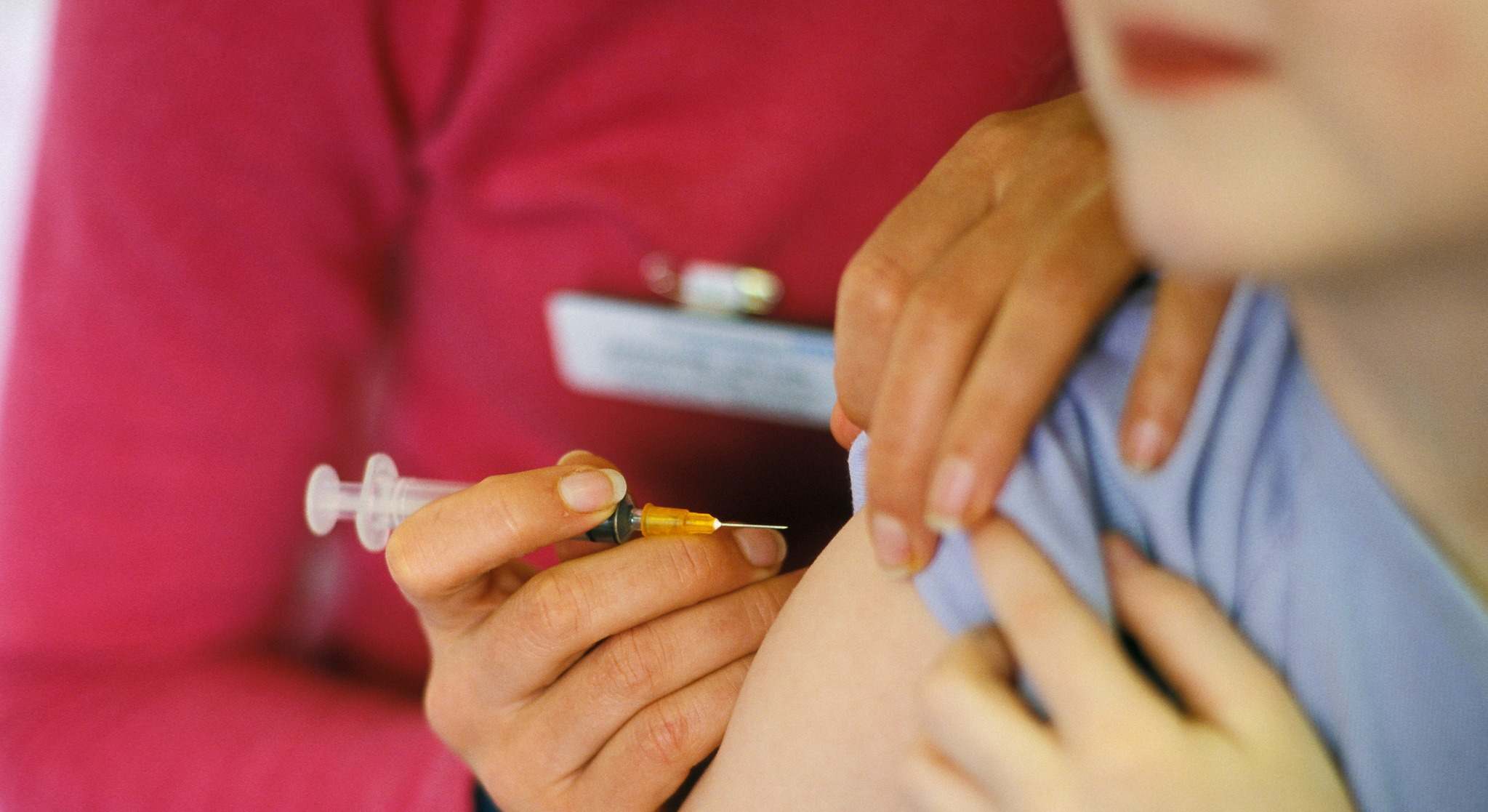 Niño poniéndose una vacuna en el brazo