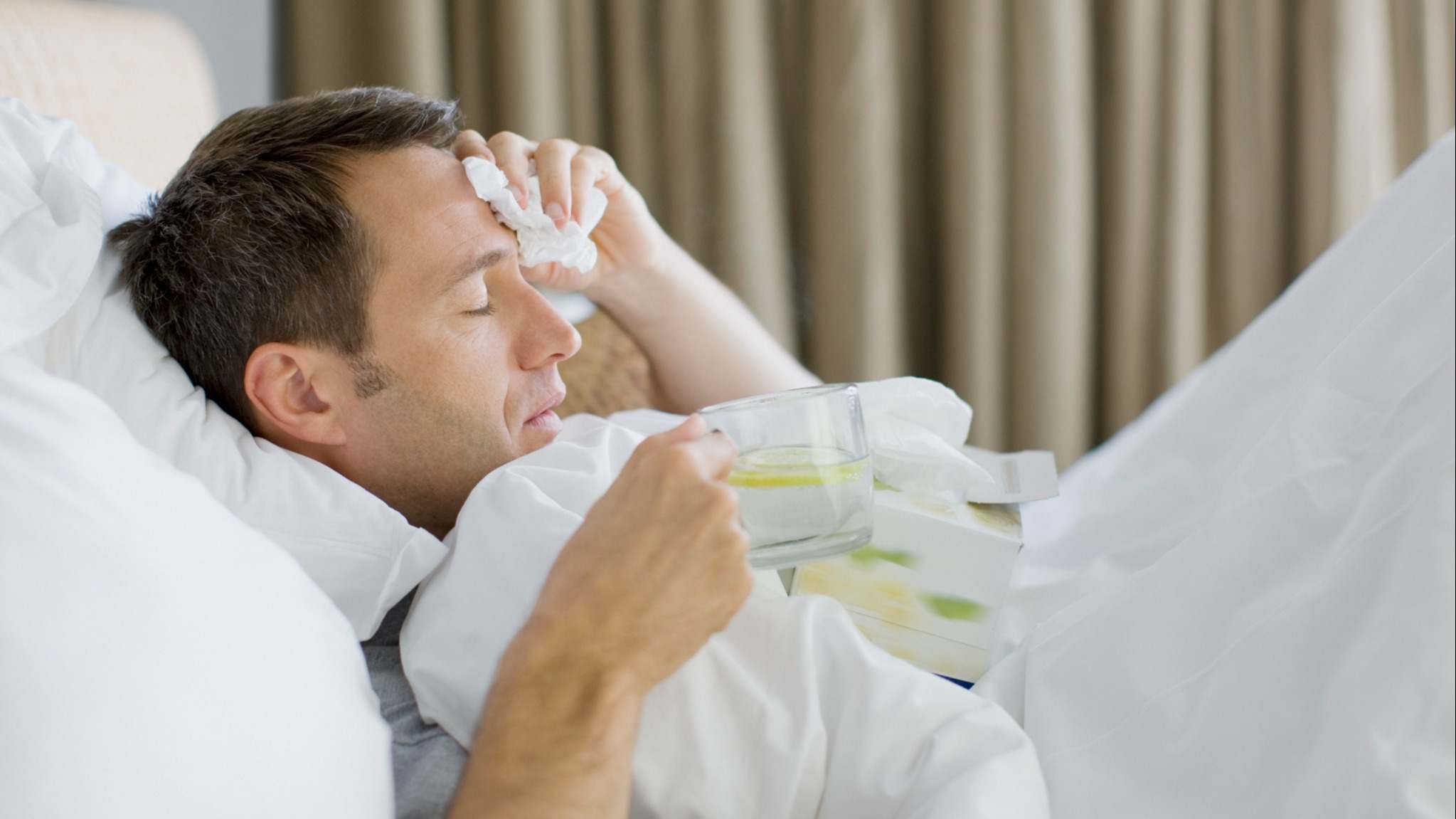 Hombre en la cama con gripe