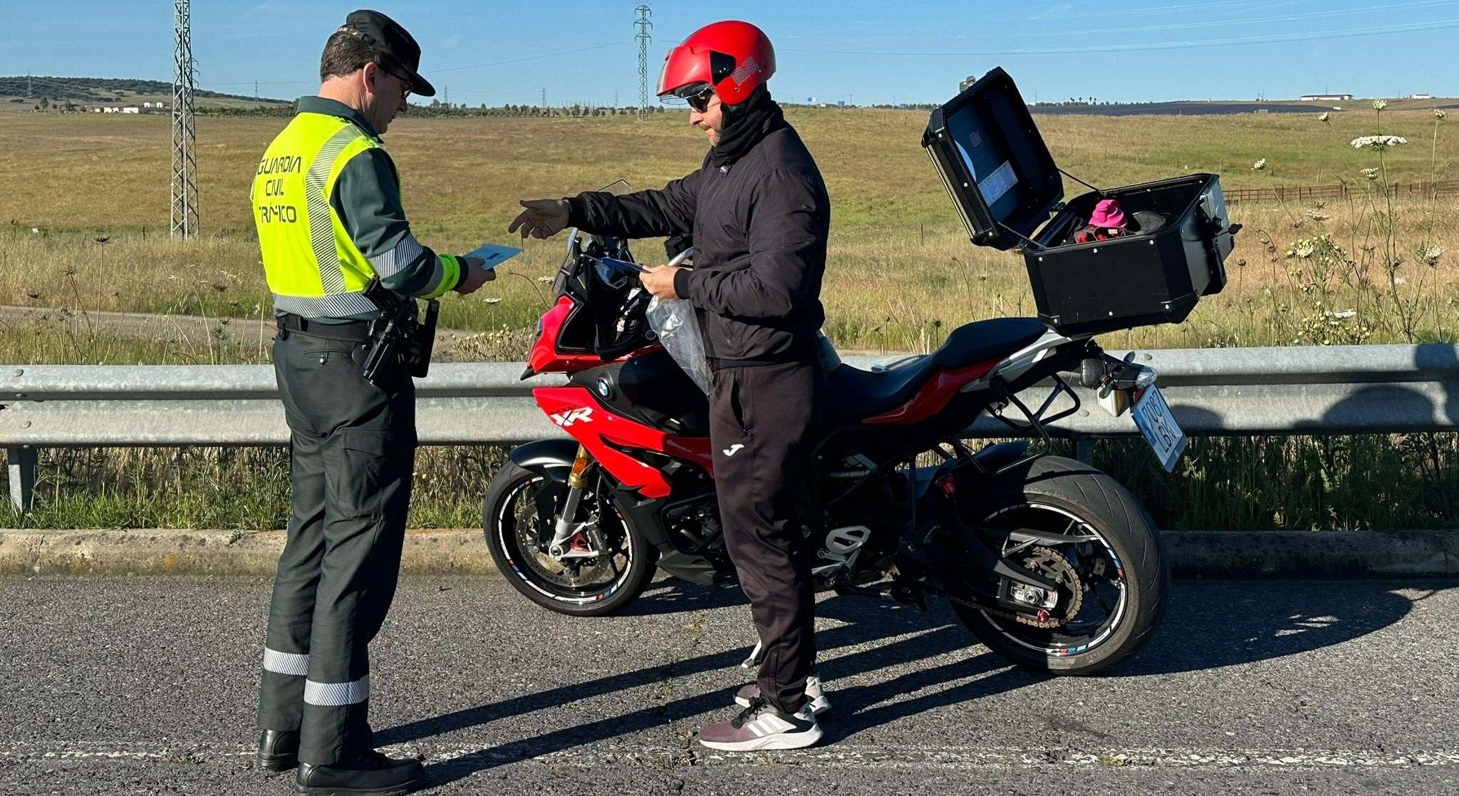 La Guardia Civil de Tráfico informa a un motorista sobre las normas de circulación por carretera