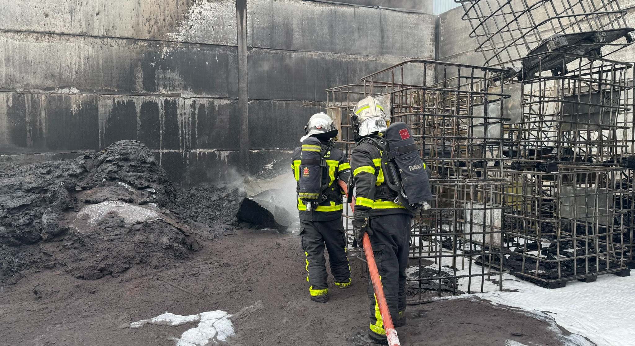 Dos bomberos de la Comunidad de Madrid trabajan en la extinción del incendio en Parla