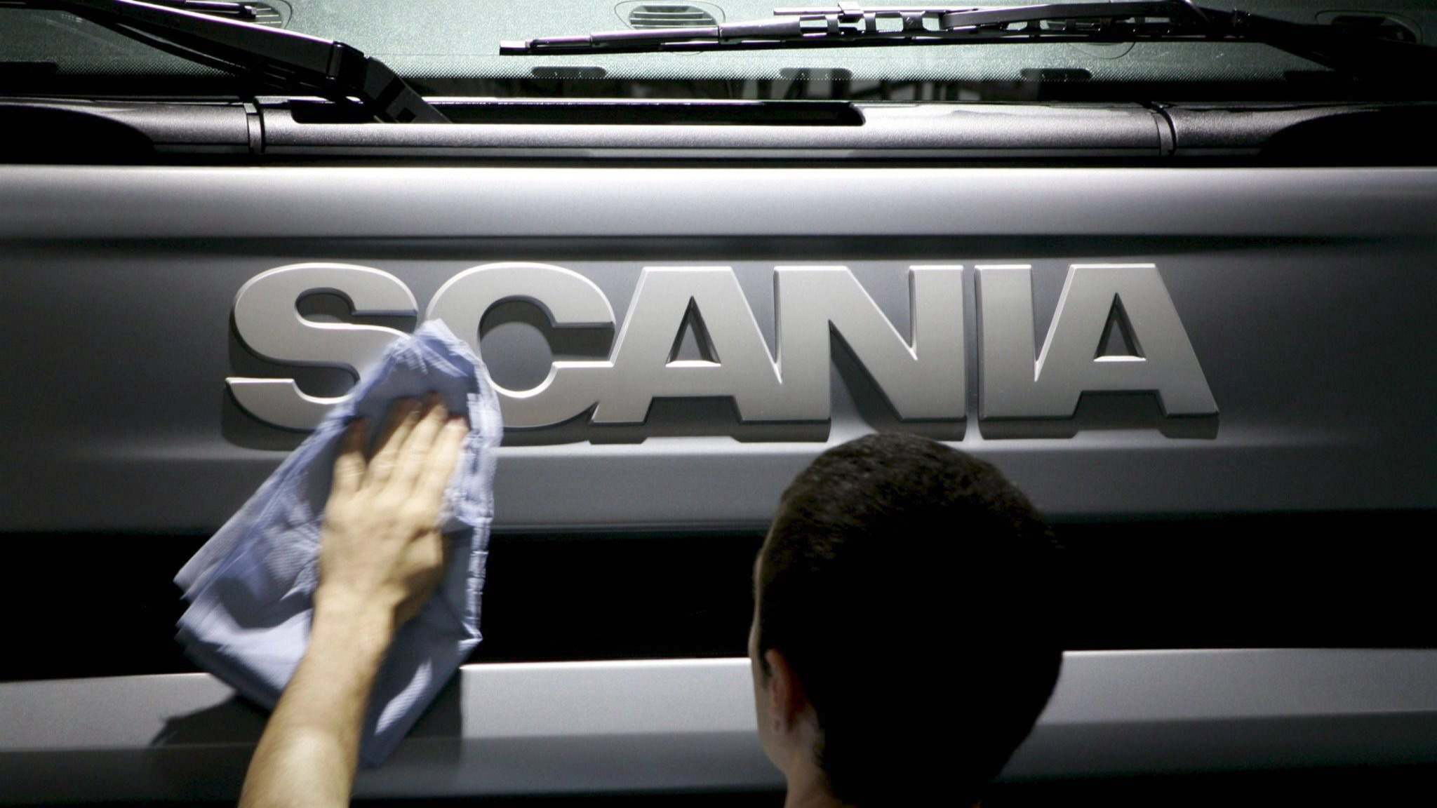 Una persona limpia el frontal de un camión de Scania