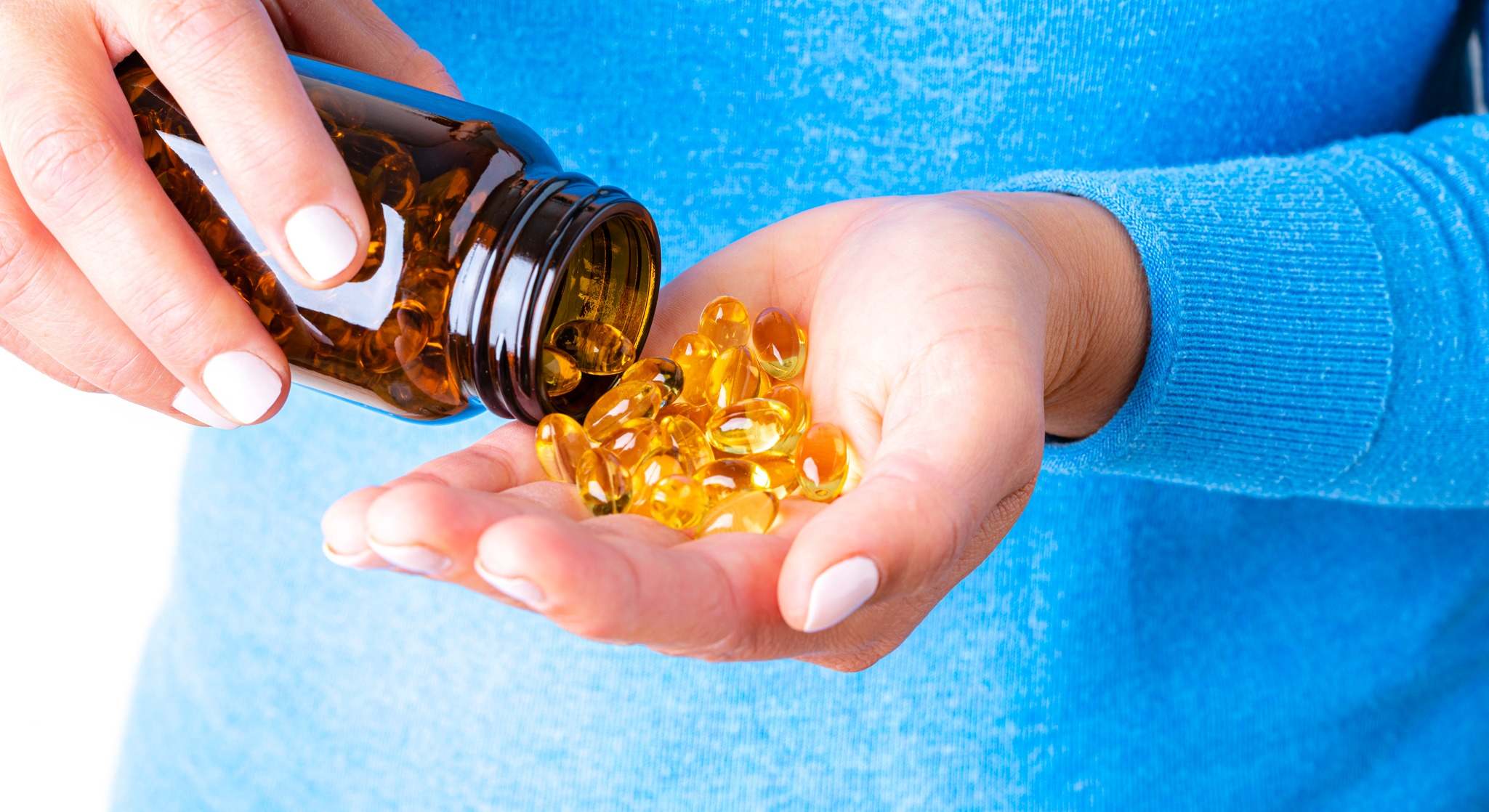 Mujer con cápsulas de omega-3 en la mano