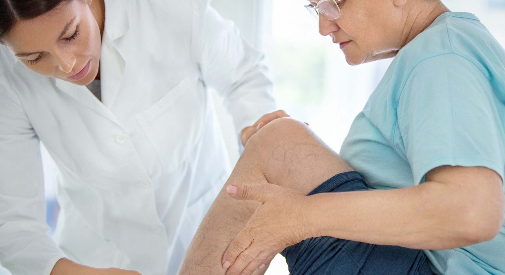 Paciente con médico examinando sus piernas