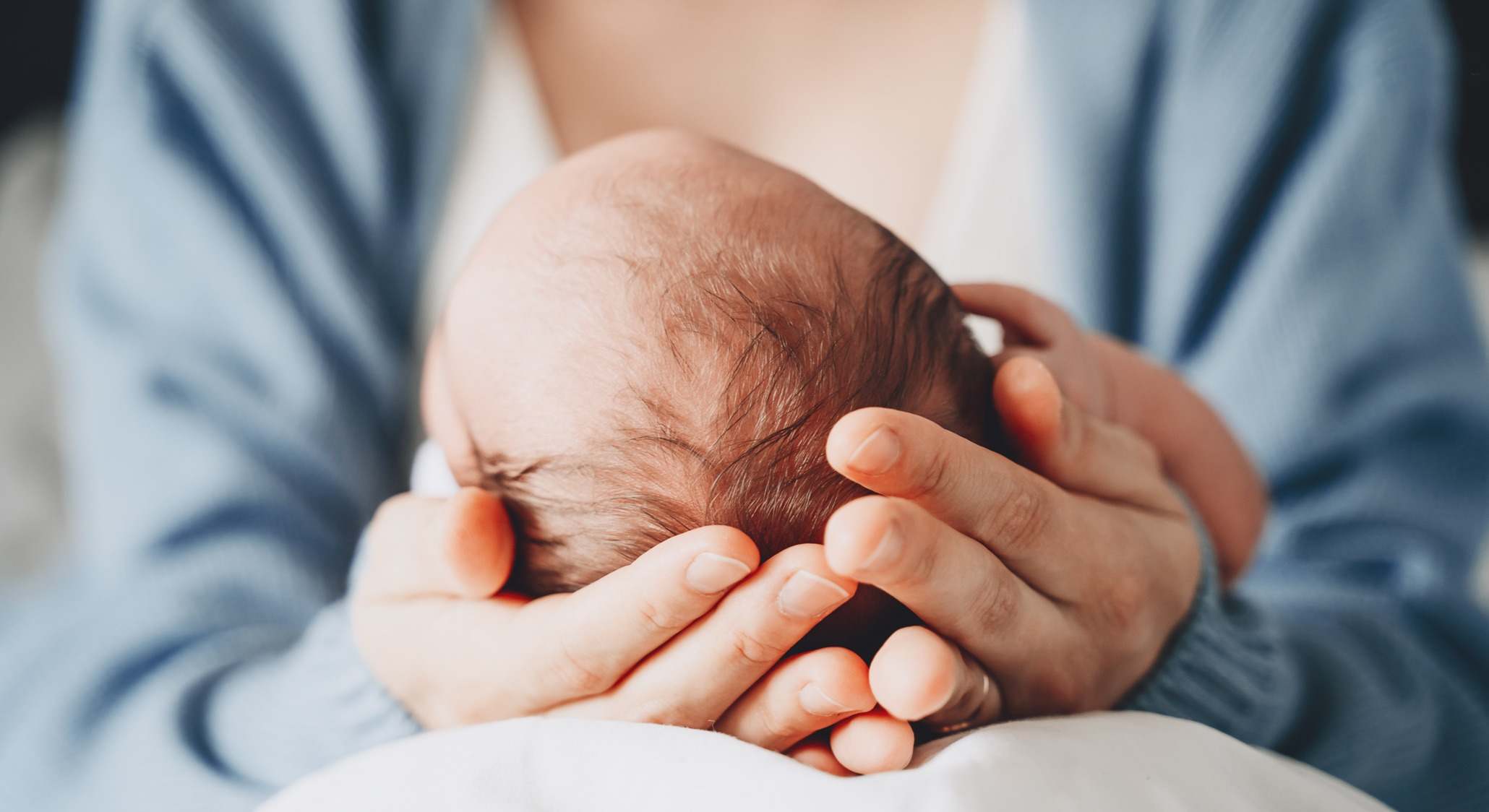 Bebé sujetado por su madre