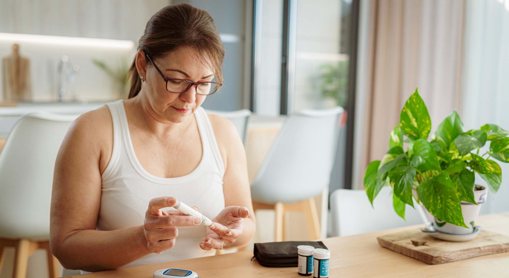Mujer midiéndose la glucosa en casa