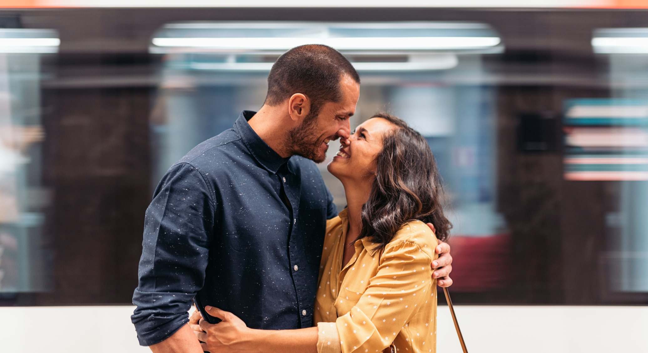 Pareja de enamorados sonriendo mientras pasa el tren