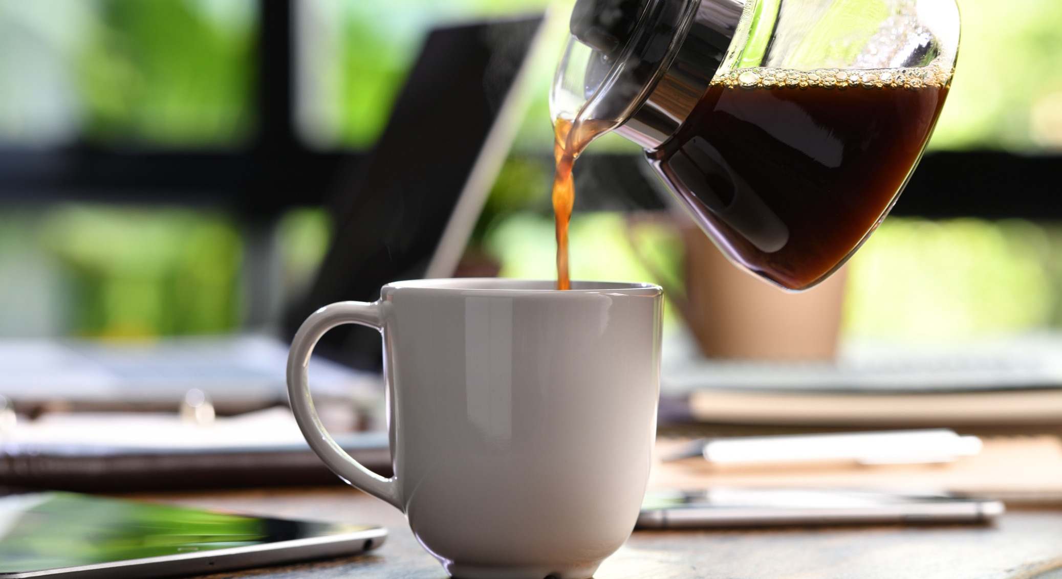 Una mano vertiendo café en una taza
