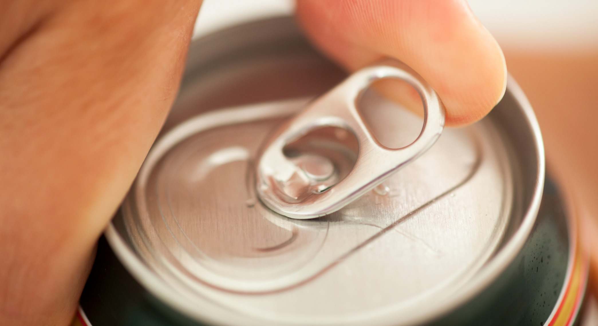Mano abriendo una lata de refresco