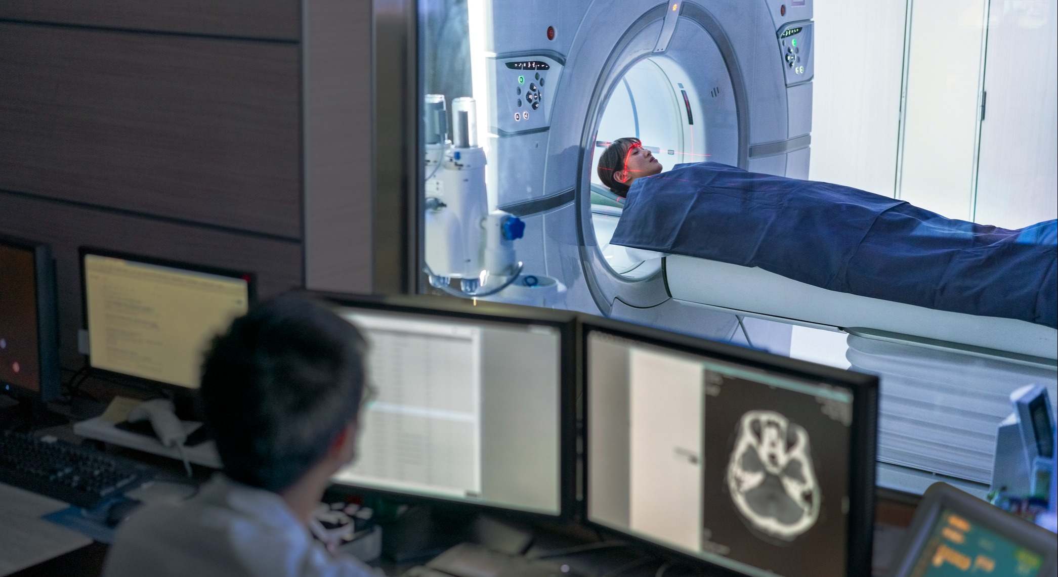 Doctor examinando la exploración mientras el paciente en el escáner MRI