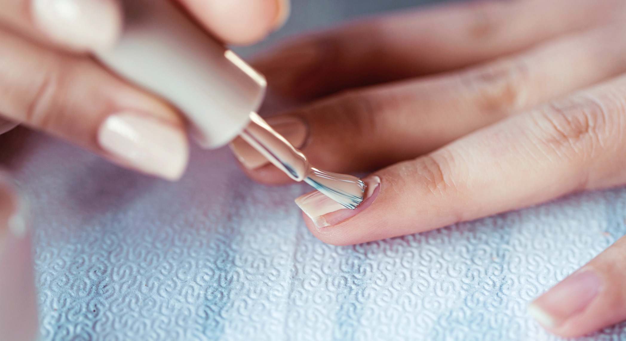 Mano pintándose las uñas