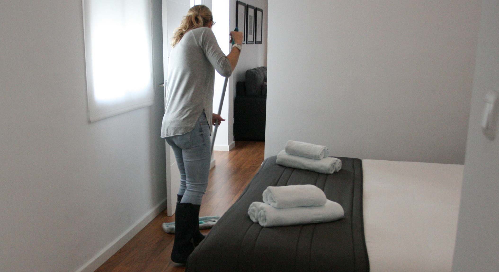 Una mujer limpia una habitación.