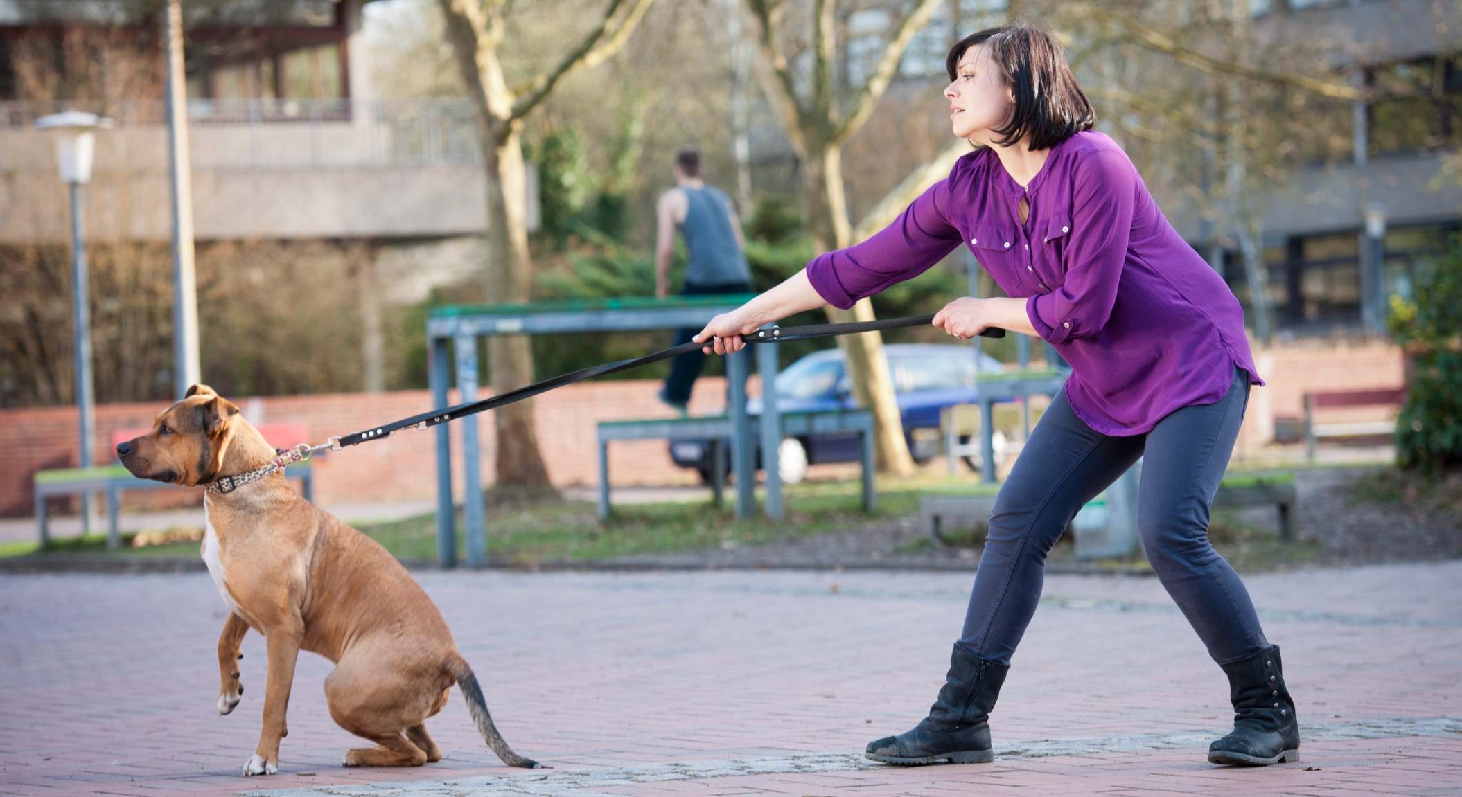 Mujer controlando que su perro no tire de la correa