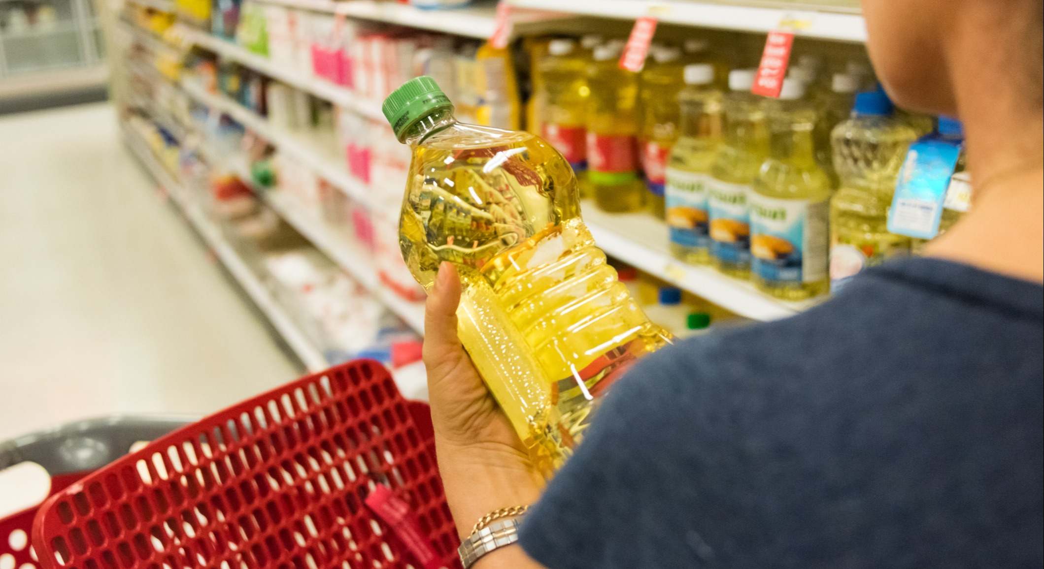 un cliente sostiene una botella de aceite de girasol