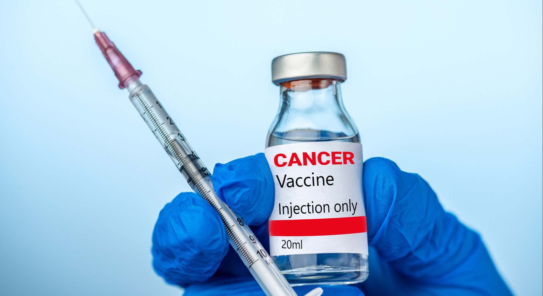 Enfermera sostienen la vacuna contra el cáncer y la jeringa con su guante azul