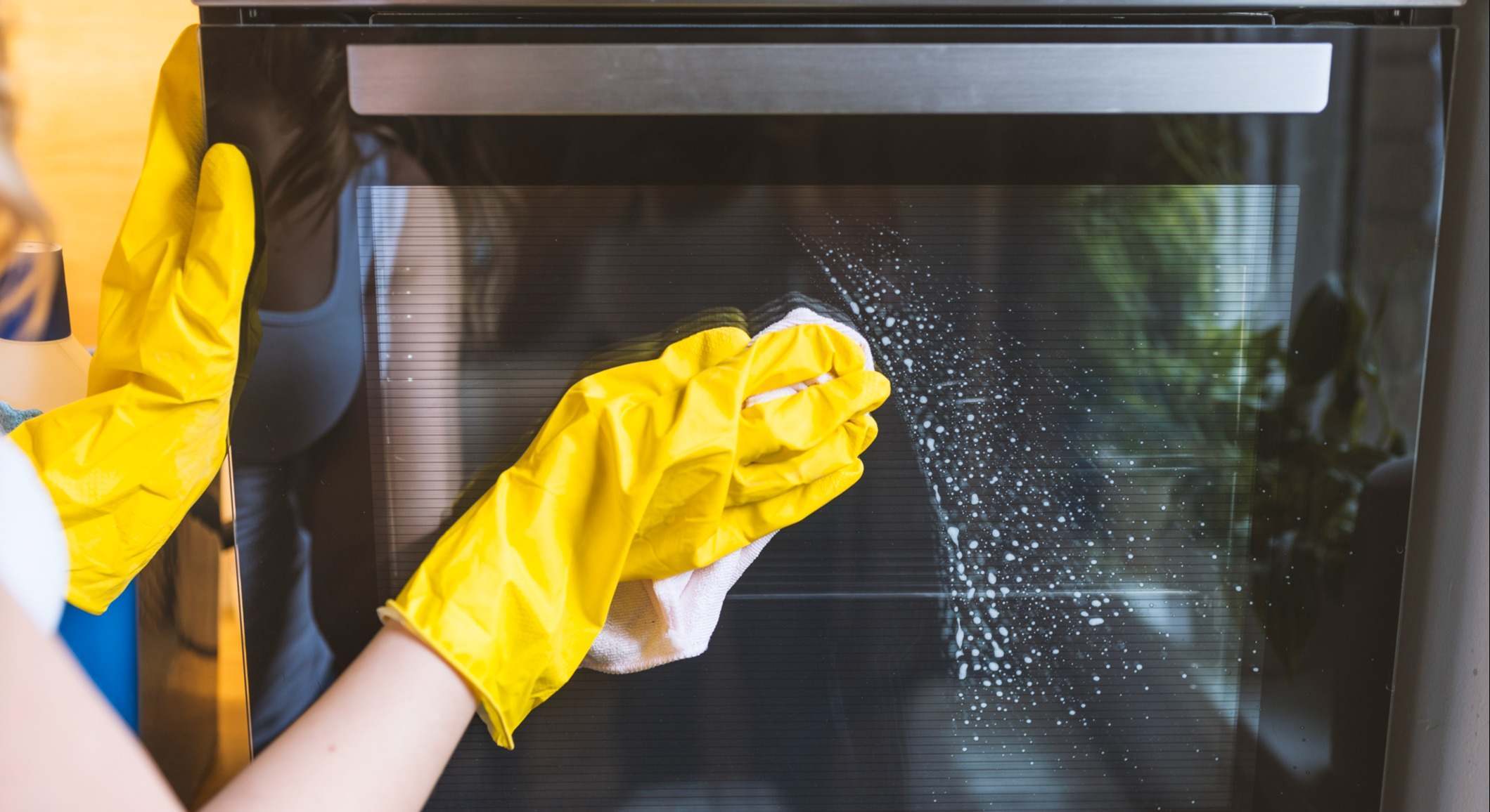 Imagen de una persona limpiando un horno