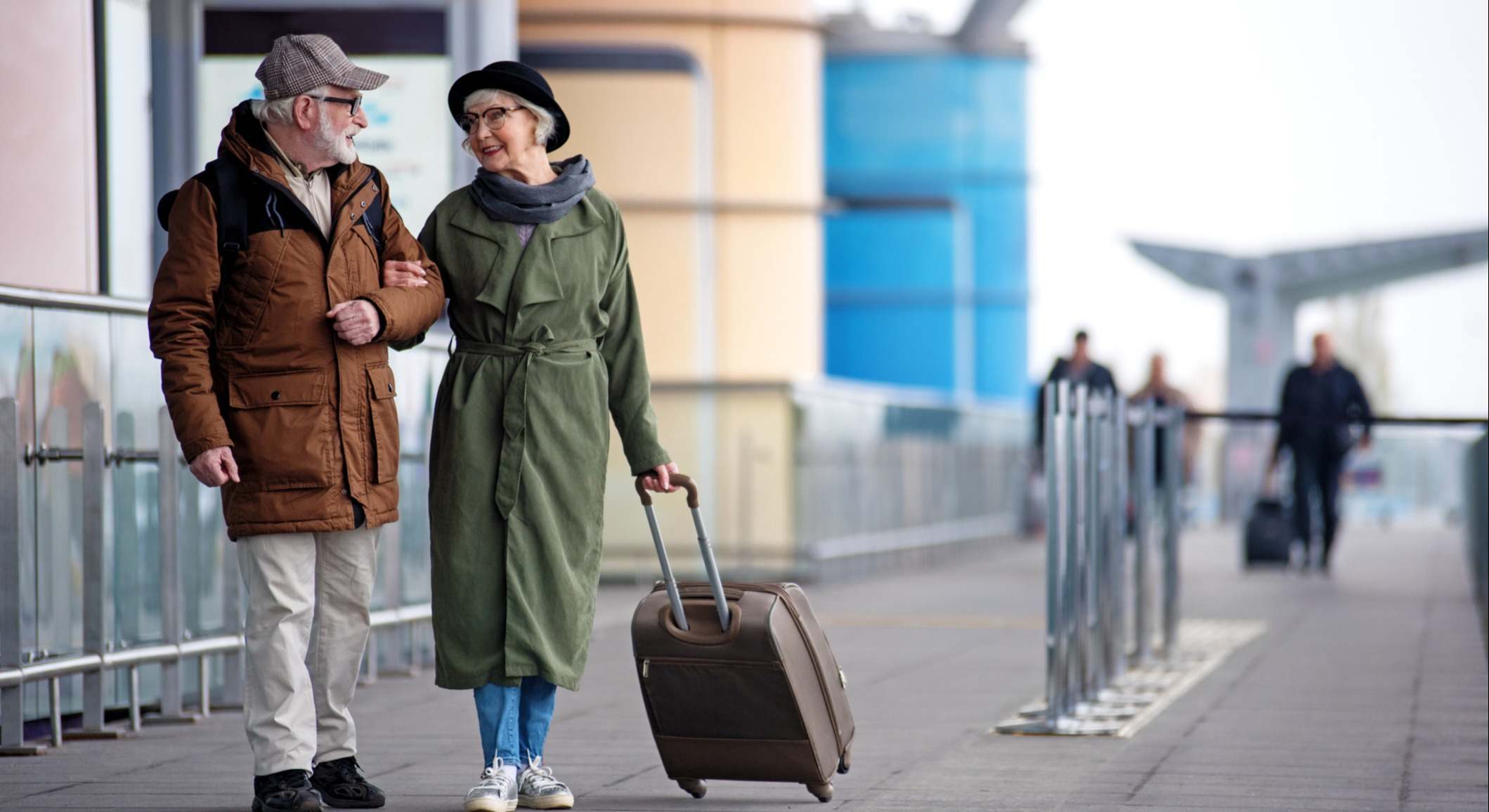 Dos personas mayores caminando por el aeropuerto