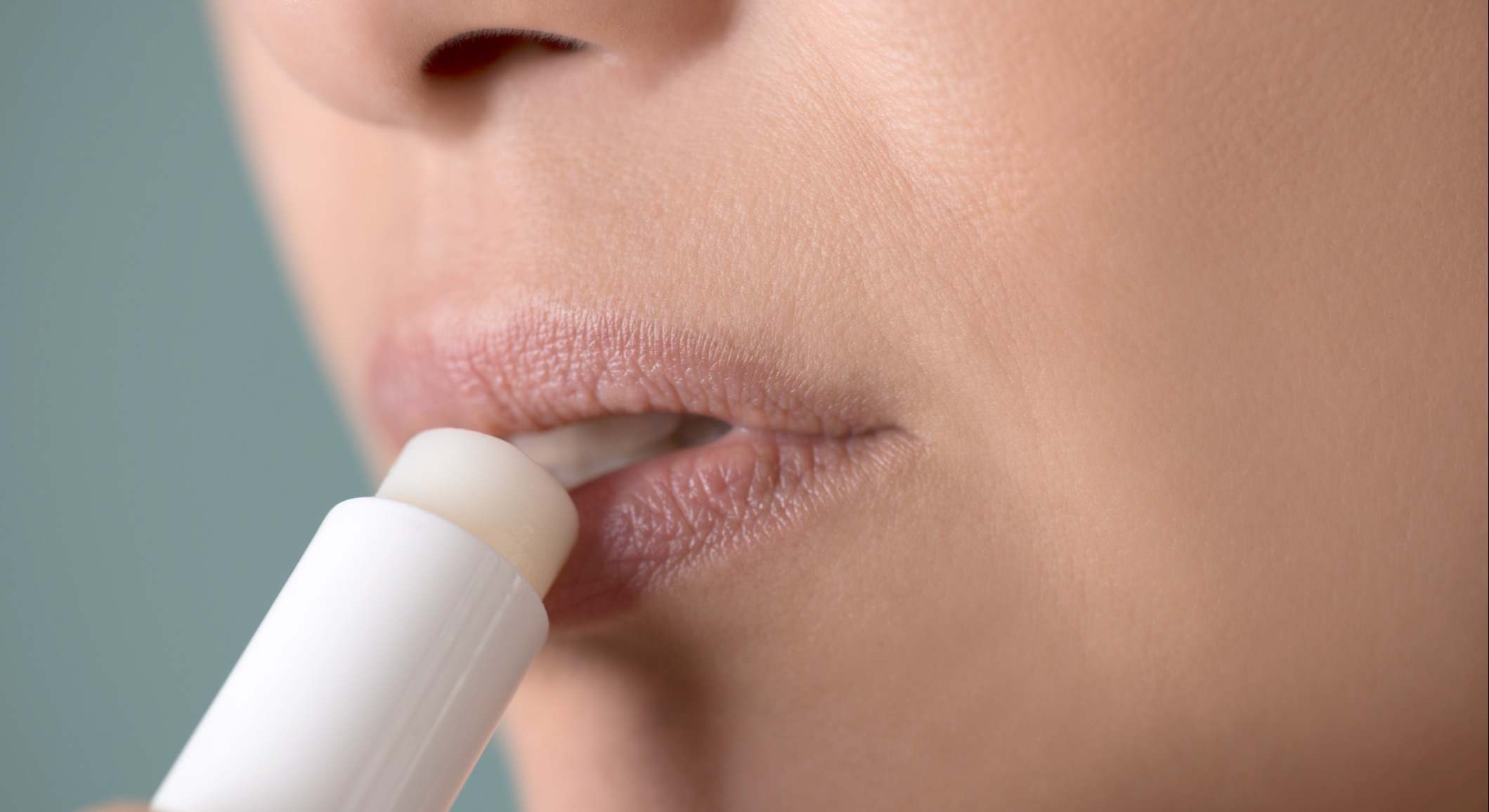 Mujer aplicándose un bálsamo en los labios
