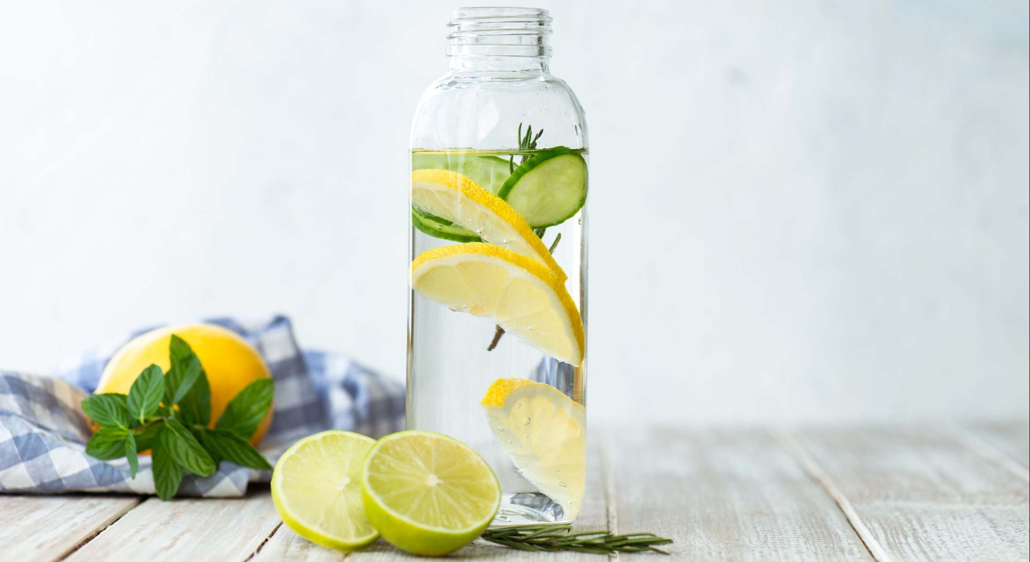 Agua con limón embotellada sobre una mesa de madera