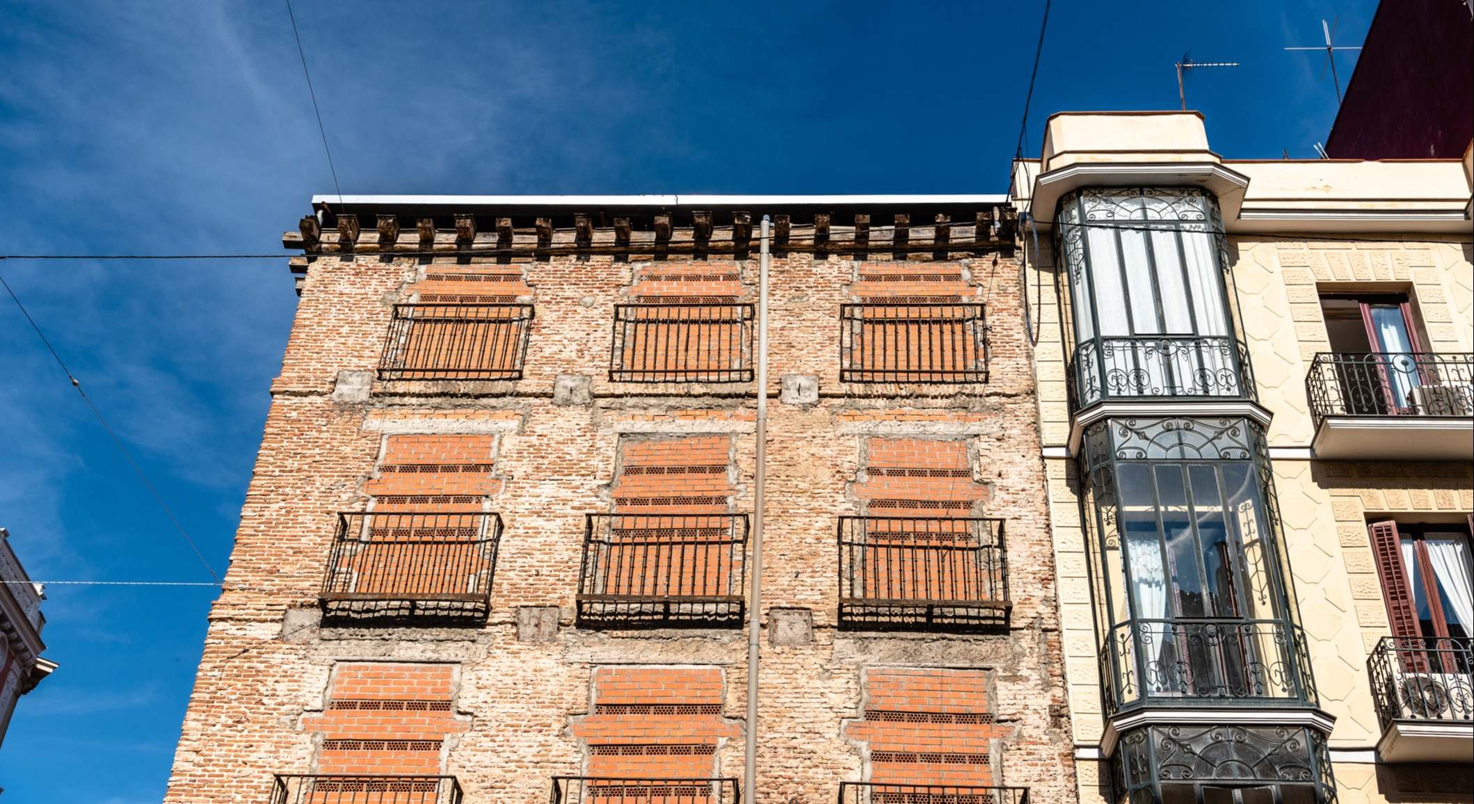 Antiguo edificio residencial con ventanas tapiadas para evitar la entrada de okupas
