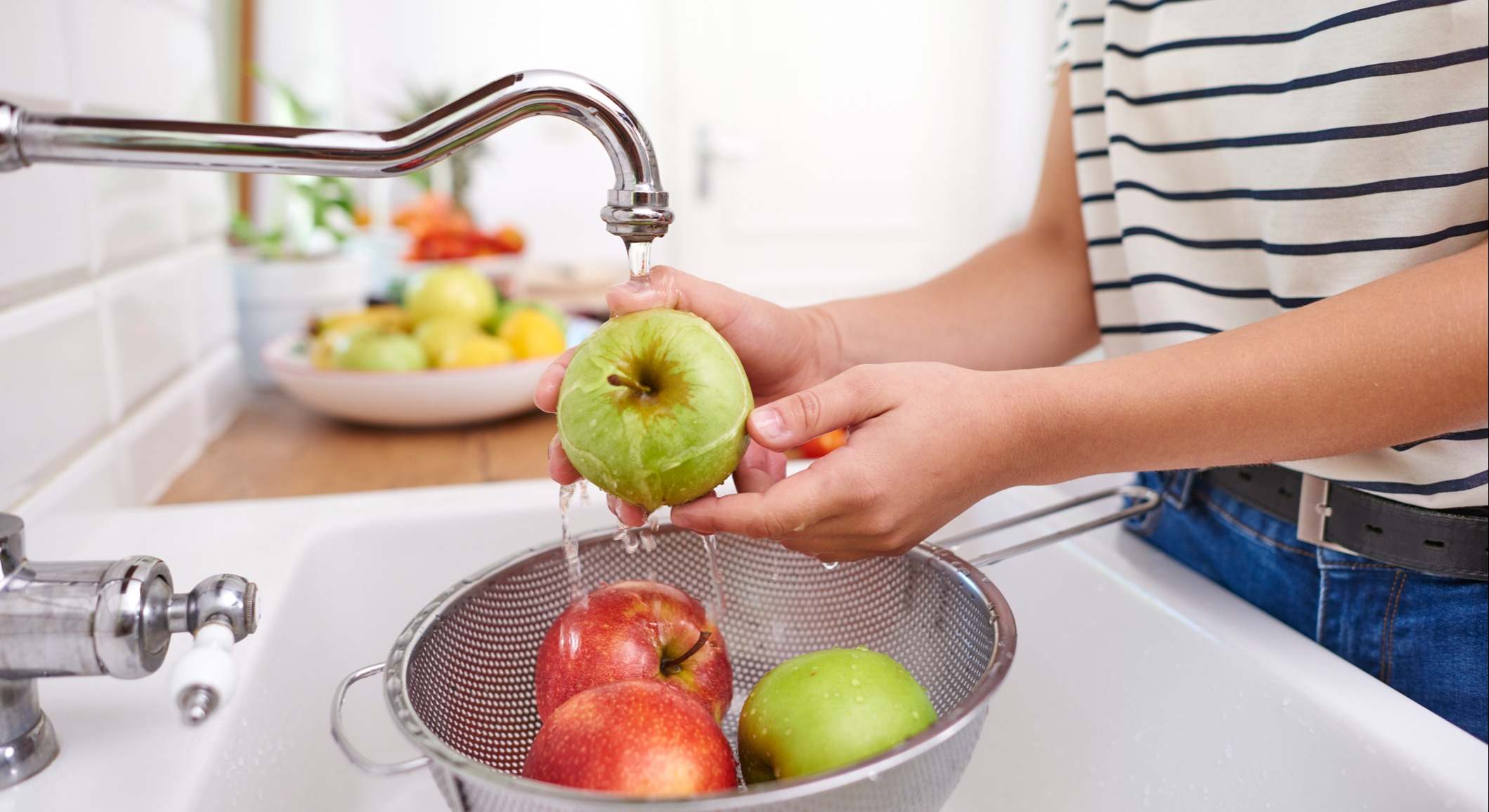 Mujer lavando manzanas frescas de temporada