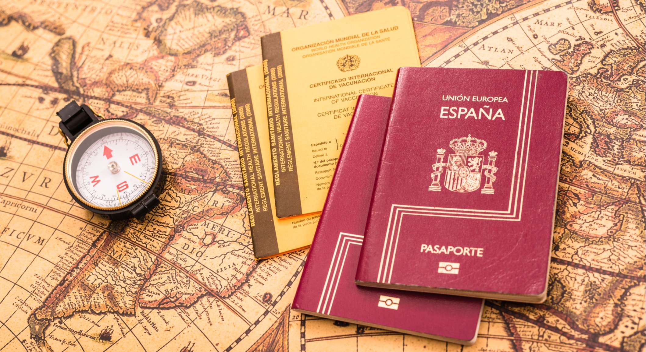 Pasaporte español junto a la tarjeta internacional de vacunación